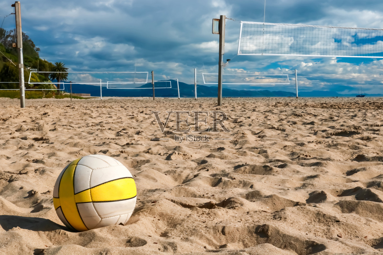 近景排球与网球场和球场一起坐在沙滩上照片摄影图片