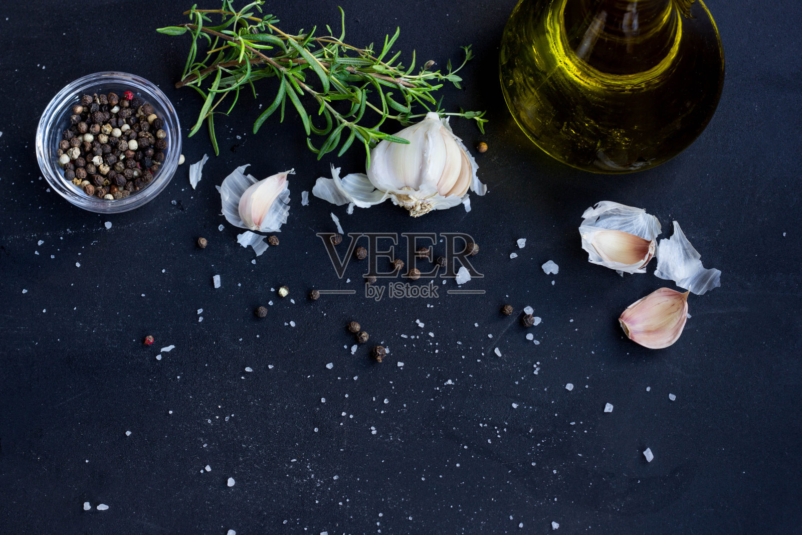 新鲜香草，大蒜，胡椒和橄榄油在黑色背景照片摄影图片