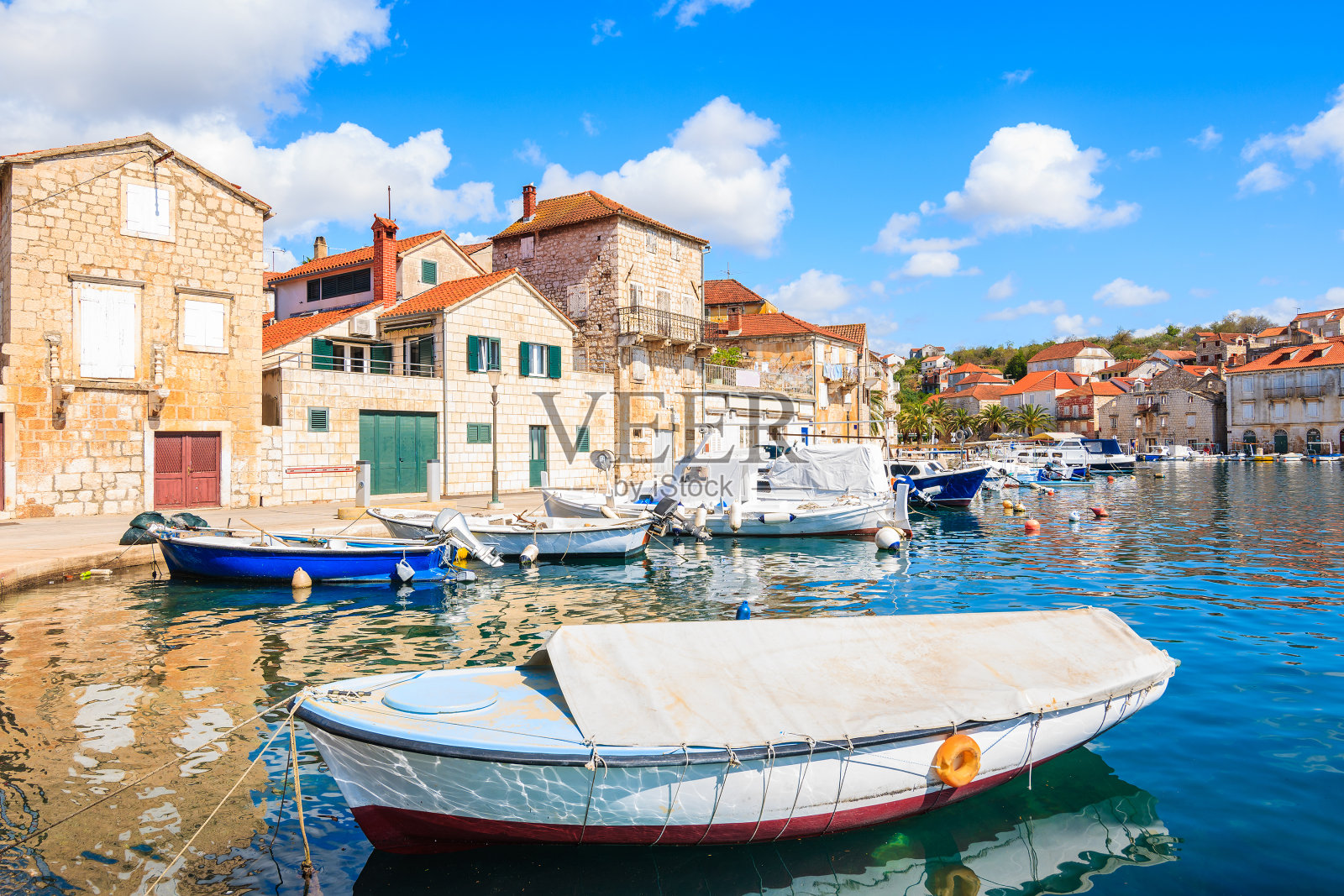 克罗地亚布拉克岛，米尔纳港，五颜六色的渔船和房屋照片摄影图片