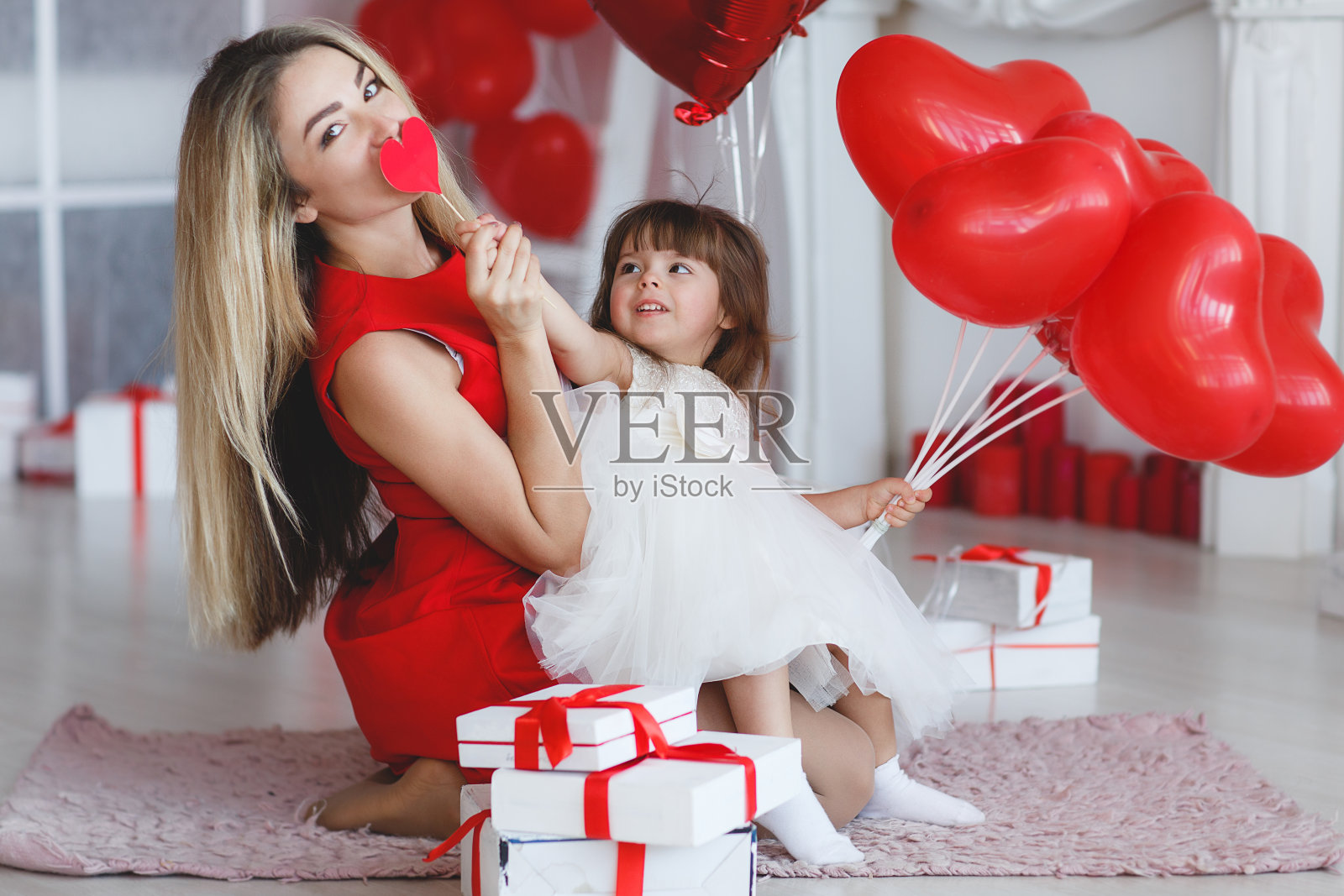 快乐的妈妈和女儿在情人节解析礼物照片摄影图片
