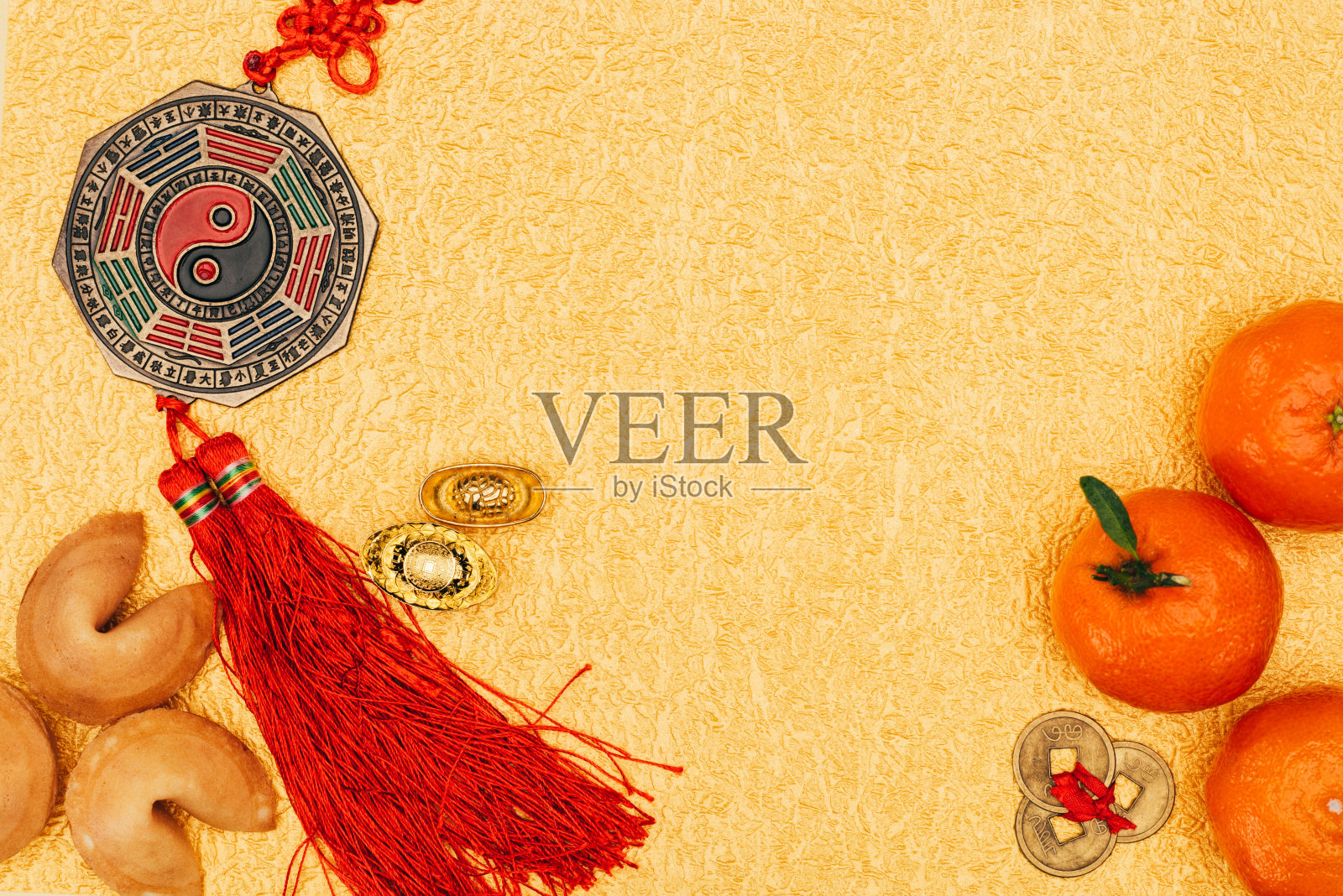 俯视图的中国护身符与橘子和幸运饼干在金色表面，中国新年的概念背景图片素材