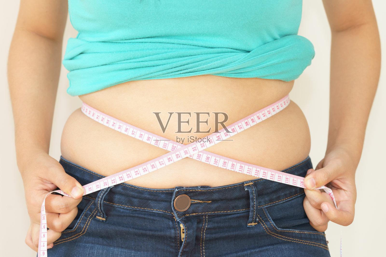 胖嘟嘟的女人试图测量自己的胖肚子照片摄影图片