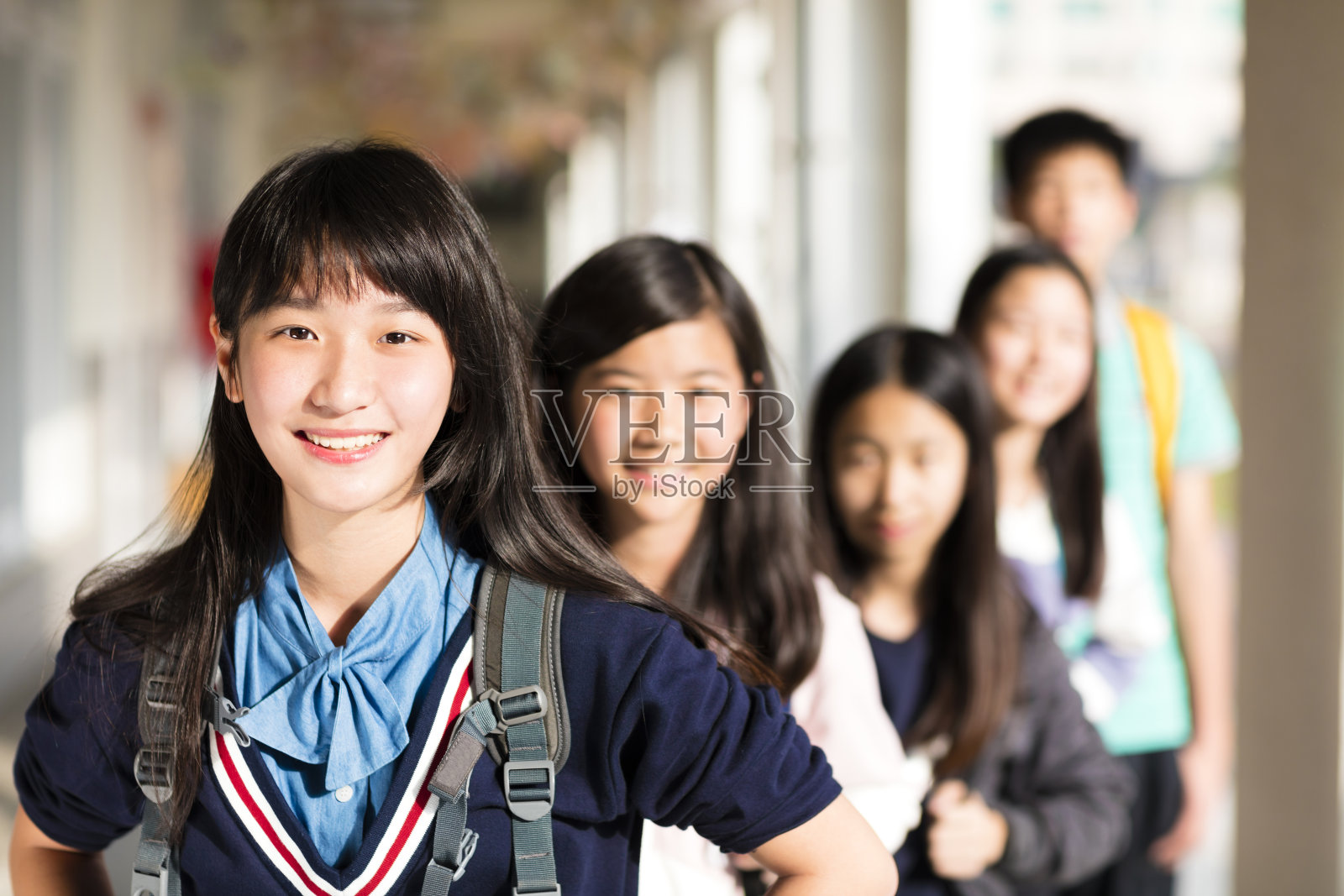一群十几岁的学生站在教室前照片摄影图片