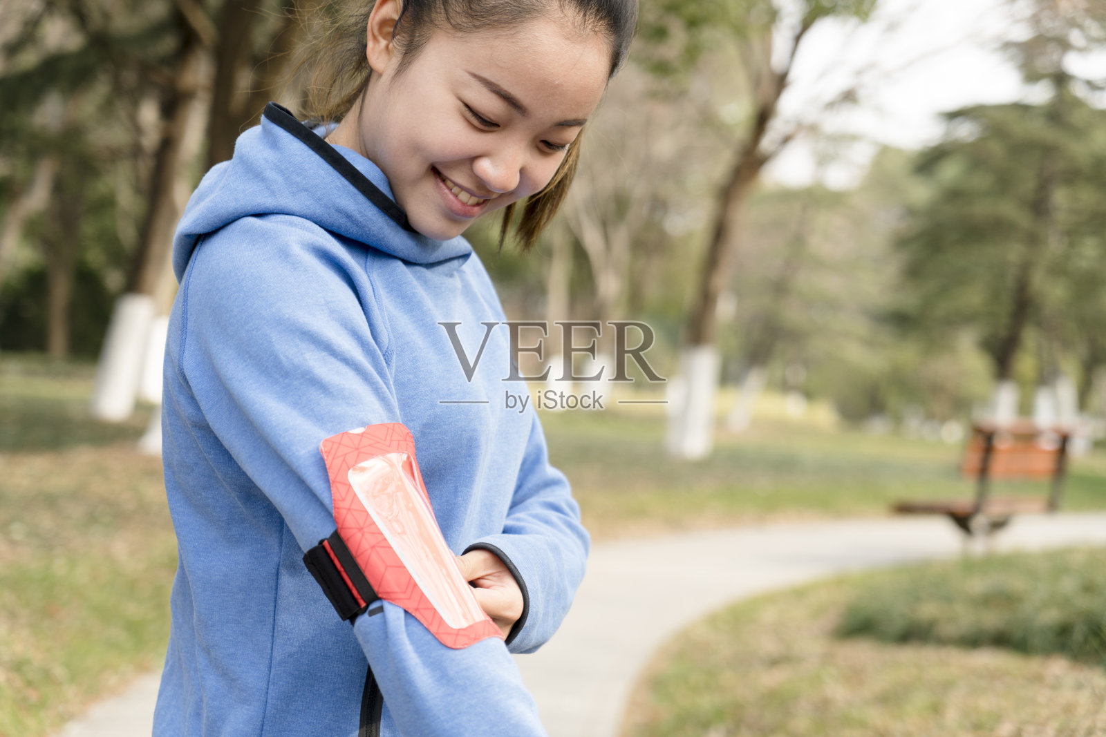年轻活跃的女子在慢跑前戴臂章照片摄影图片