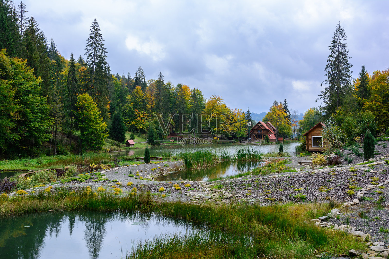 房子在湖边的森林里，秋日。落叶的风景。照片摄影图片