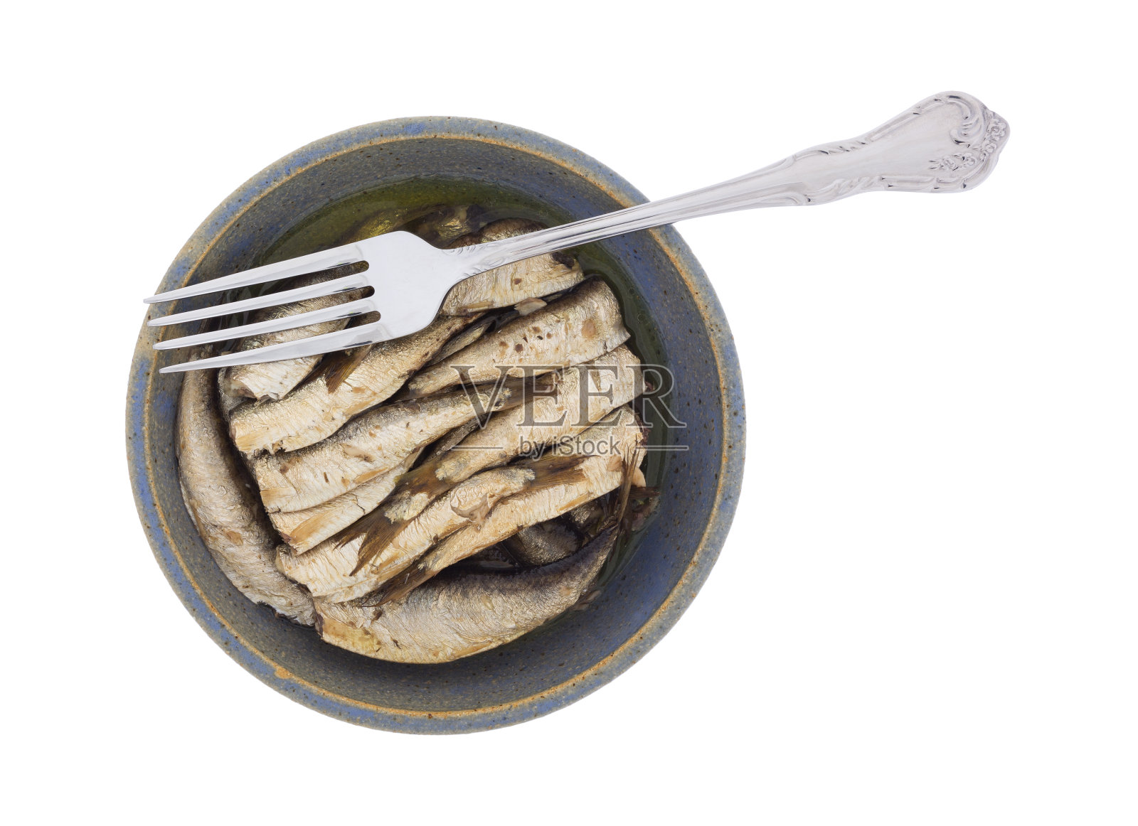 用叉子把烟熏鲱鱼放在碗里照片摄影图片