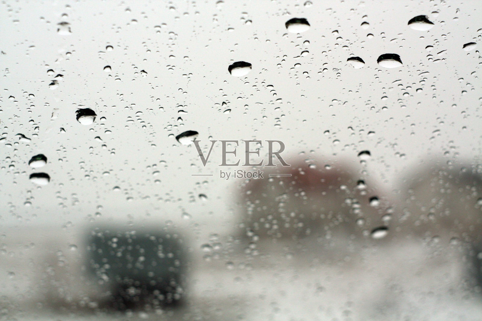 冬季透过窗户观看，以雨滴为焦点。照片摄影图片