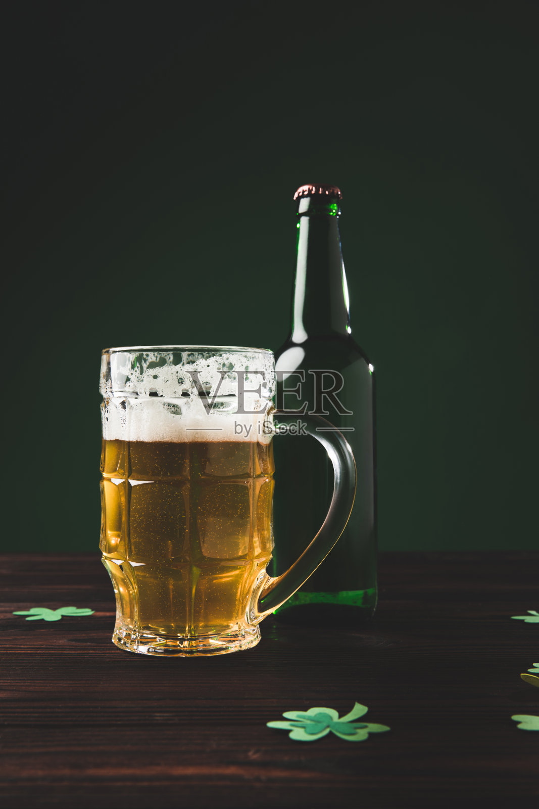 一杯啤酒和一个桌上有三叶草的玻璃瓶，圣帕特里克节的概念照片摄影图片