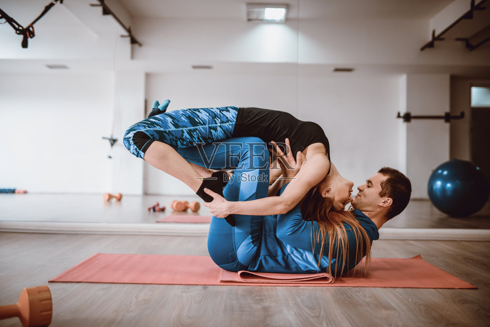 一对迷人的情侣在健身房做瑜伽普拉提运动照片摄影图片