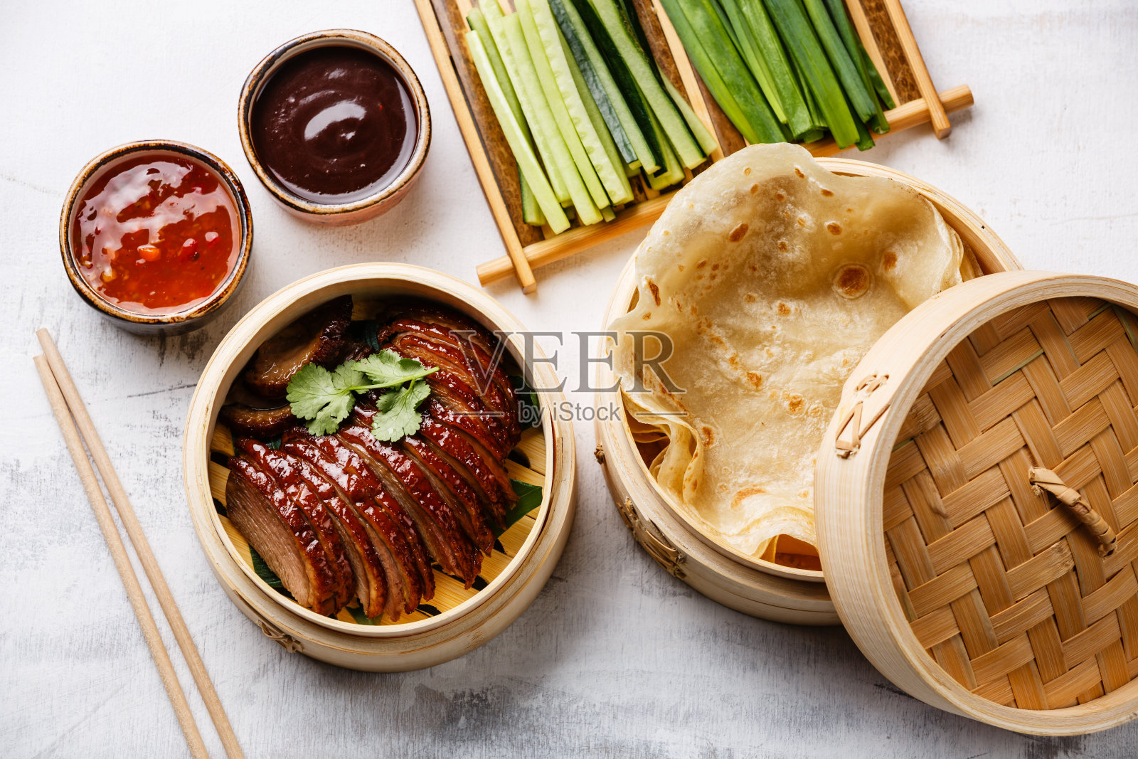 蒸笼内的北京烤鸭片和香菜照片摄影图片
