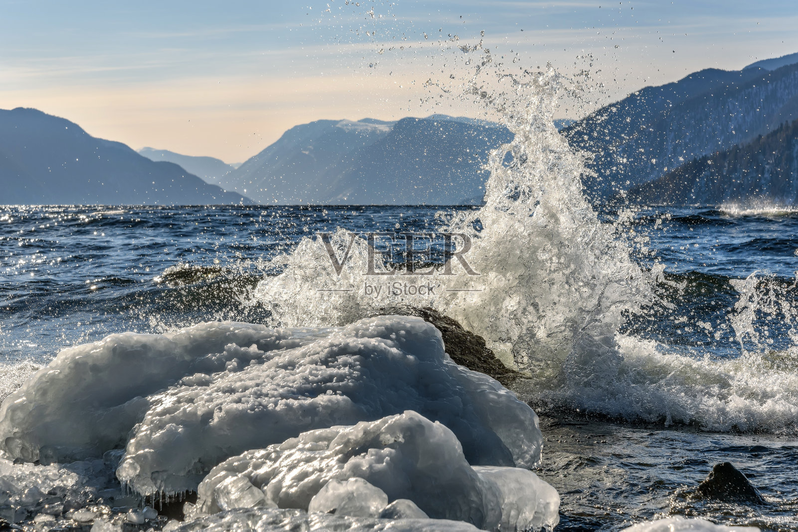 湖面上的群山波浪式地溅起冰块照片摄影图片