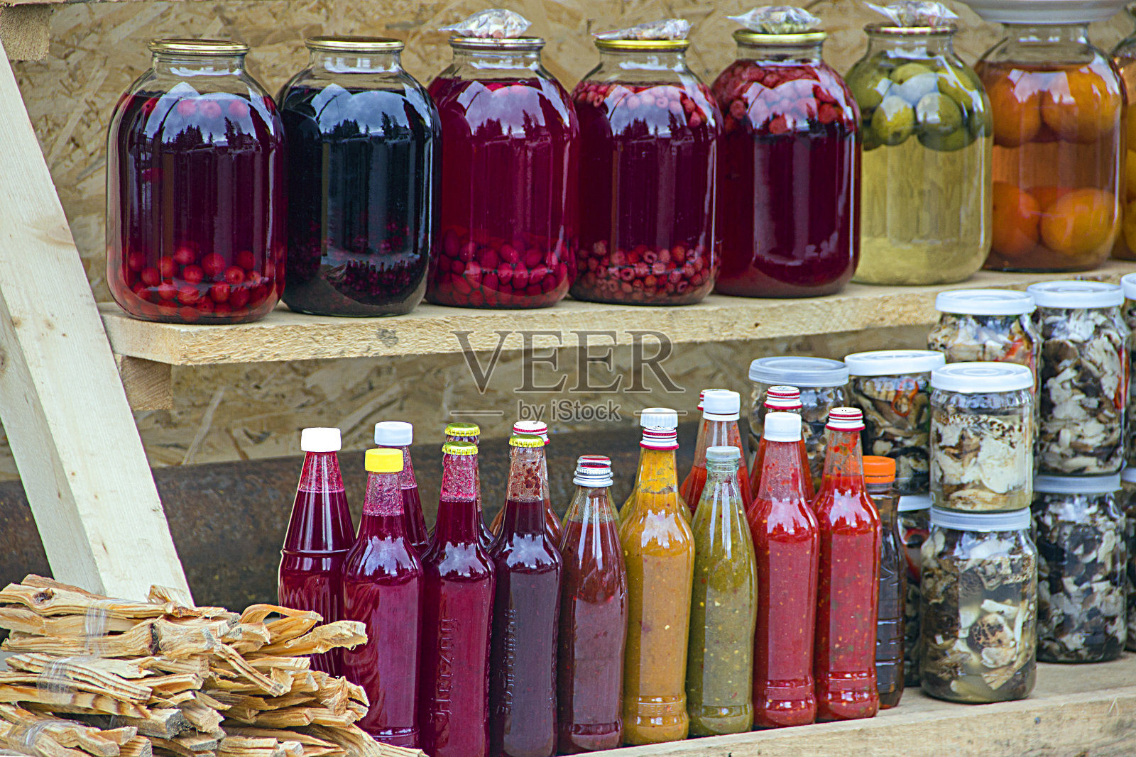 果盘，果酱，果酱和传统格鲁吉亚酱，浆果，水果和蔬菜在家。街边市场货架上的玻璃罐和瓶子装的罐头食品。照片摄影图片