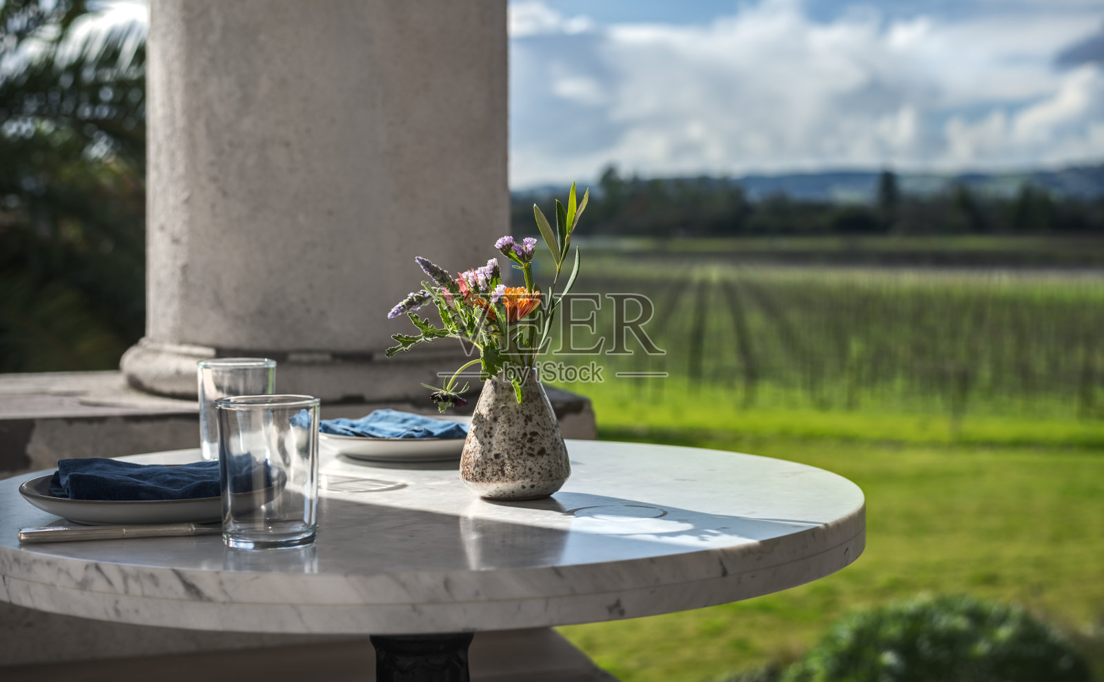 室外圆桌与晚餐设置俯瞰葡萄园照片摄影图片