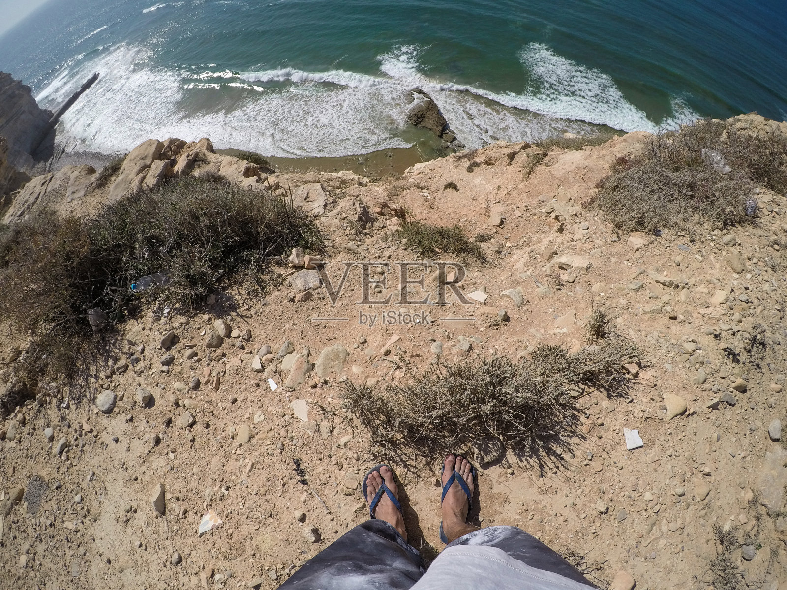 人站在悬崖的边缘，上面的海-个人视角照片摄影图片