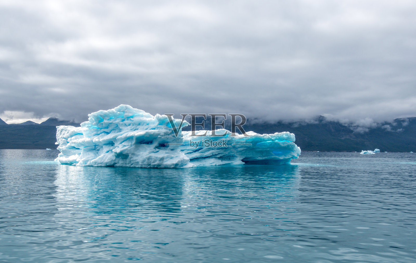 峡湾的冰山，蓝色的冰山，里面有清晰的蓝色斑点，带有大西洋天空的戏剧性情绪照片摄影图片