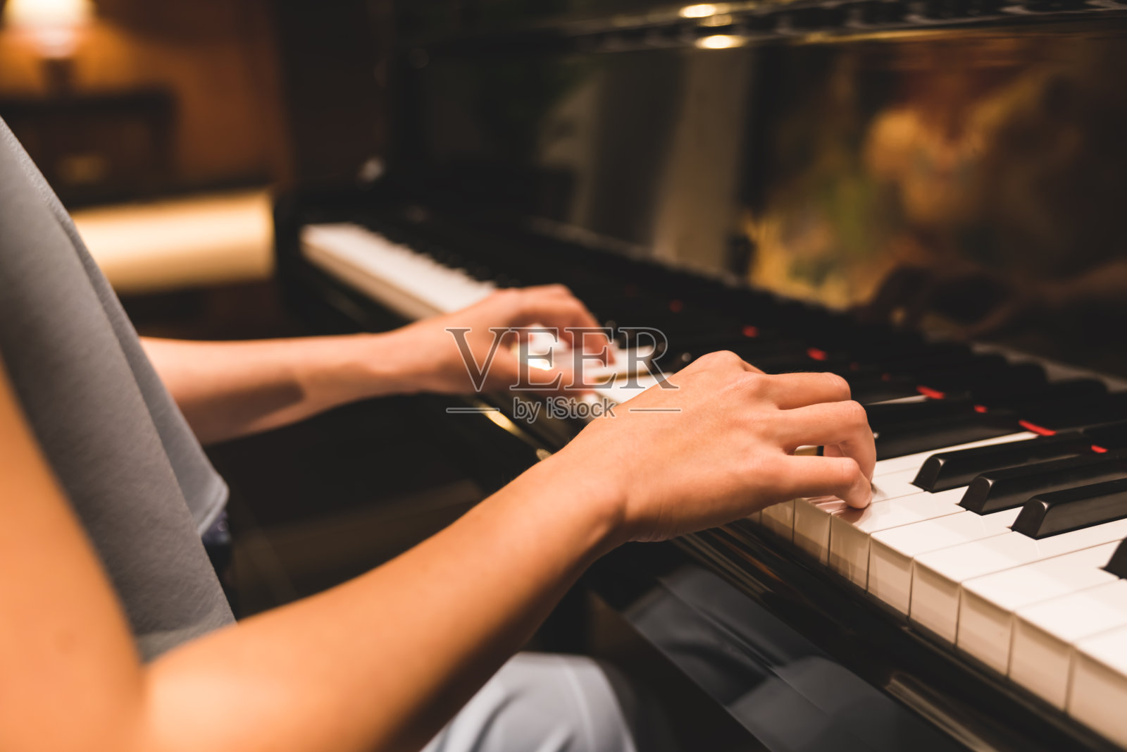 亚洲女子在浪漫的气氛中用手弹奏钢琴键盘。乐器，钢琴独奏，作曲家，爱好，实践研究，或婚礼活动的概念照片摄影图片
