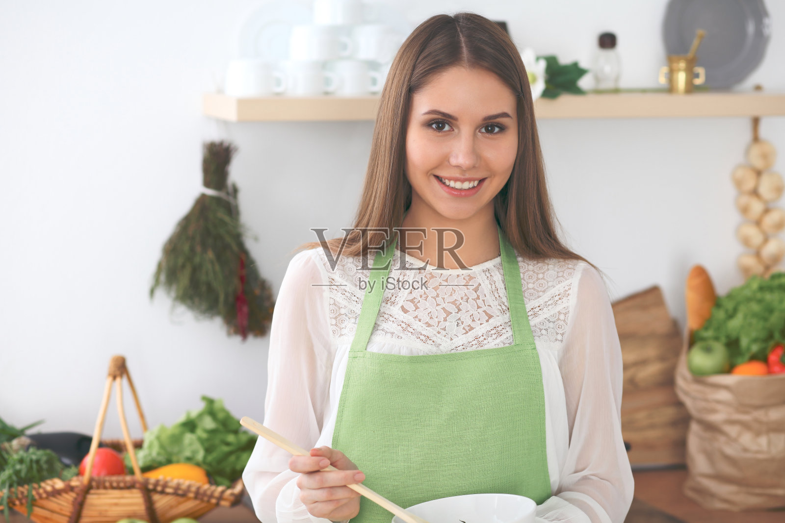 年轻快乐的女人在厨房做饭。健康饮食、生活方式和烹饪理念照片摄影图片