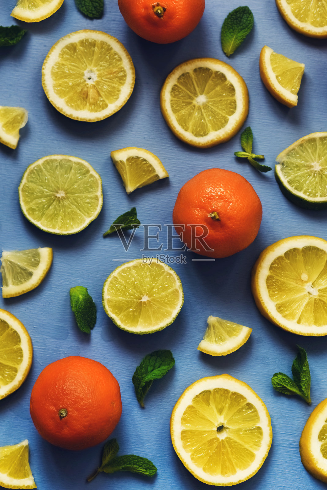 一束色彩鲜艳的新鲜水果和薄荷撒在绿松石乡村板上照片摄影图片