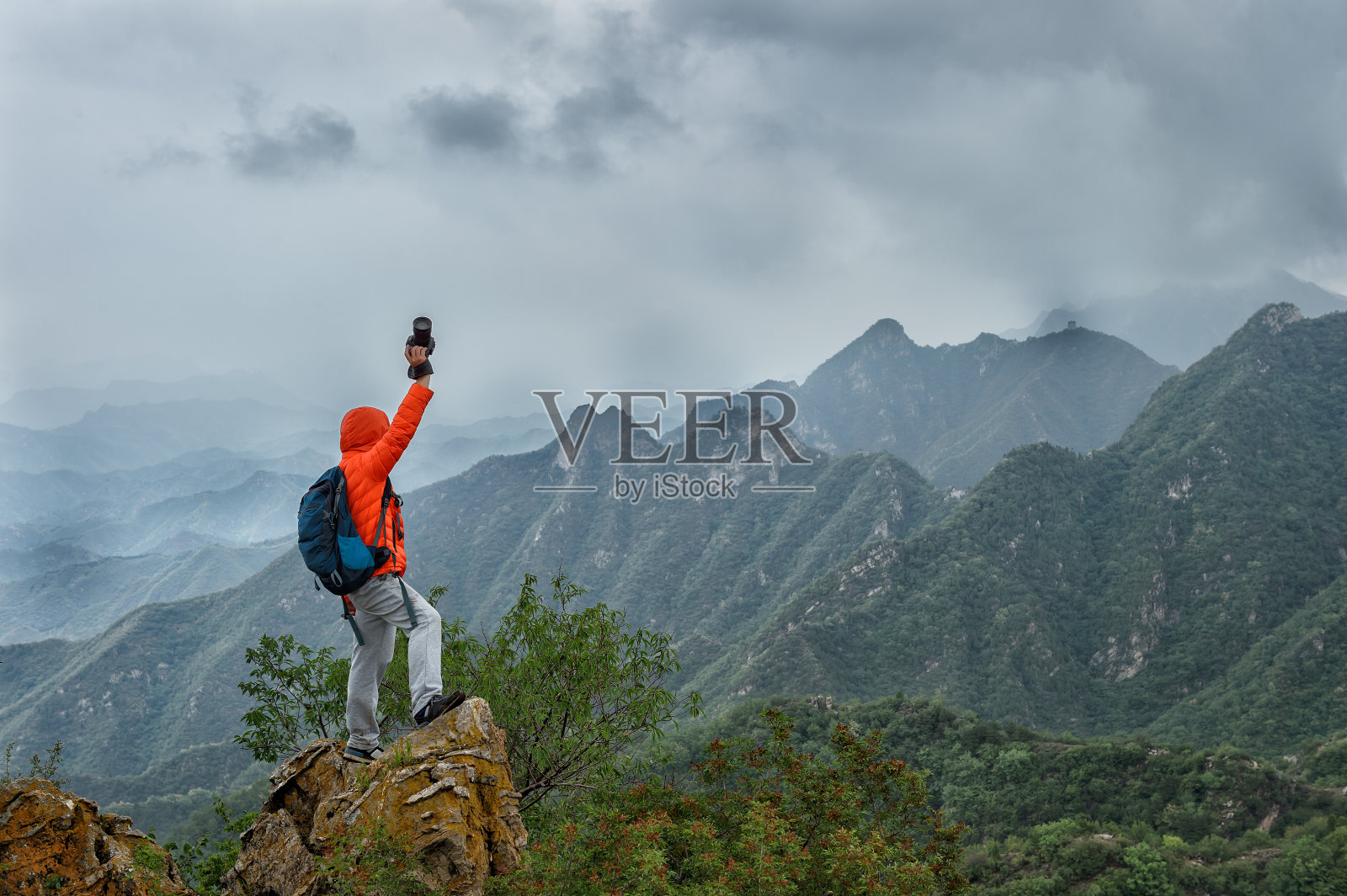 坚强的登山者站在一座山峰的顶端照片摄影图片