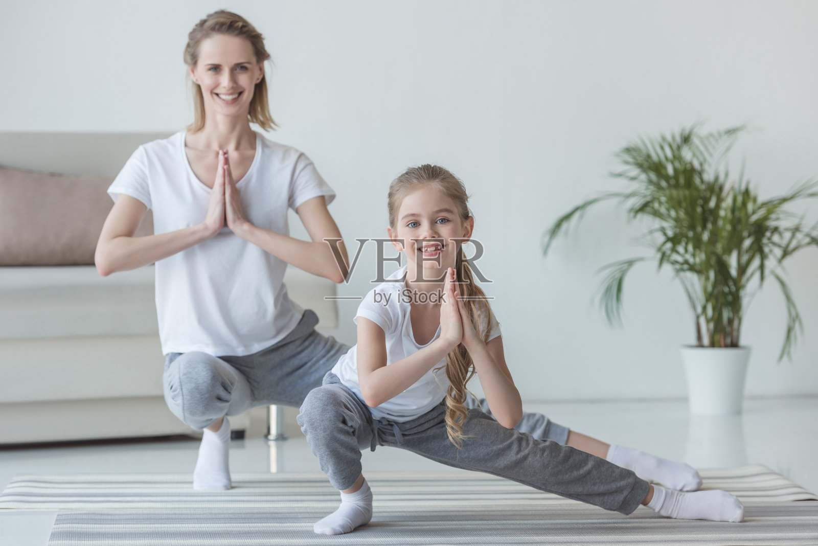 母亲和女儿在家里一起练习瑜伽照片摄影图片