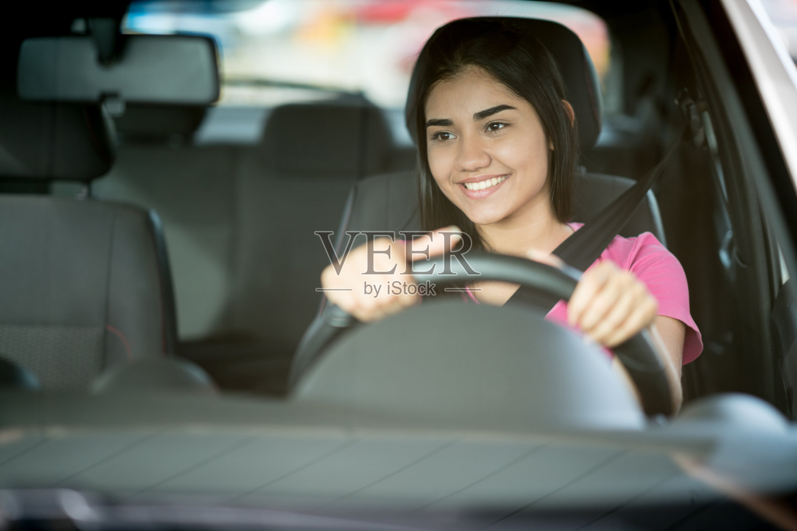 一个快乐的年轻女人开车的肖像照片摄影图片