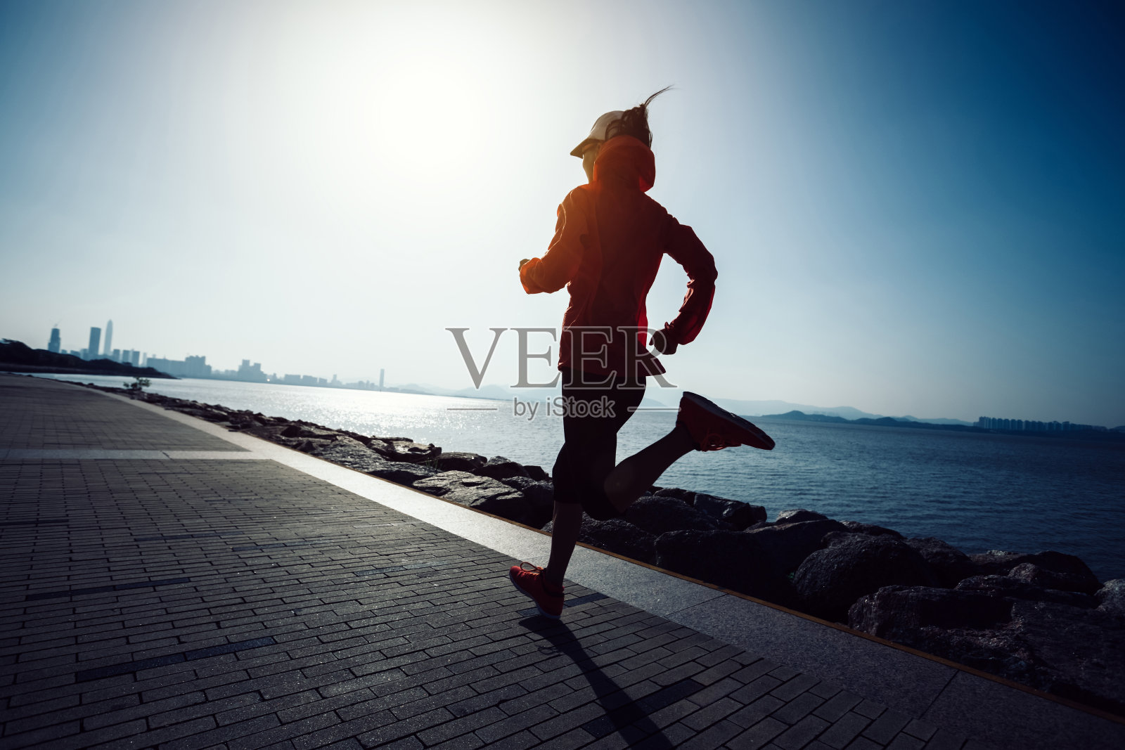 运动的年轻健身女人在日出的海边跑步照片摄影图片