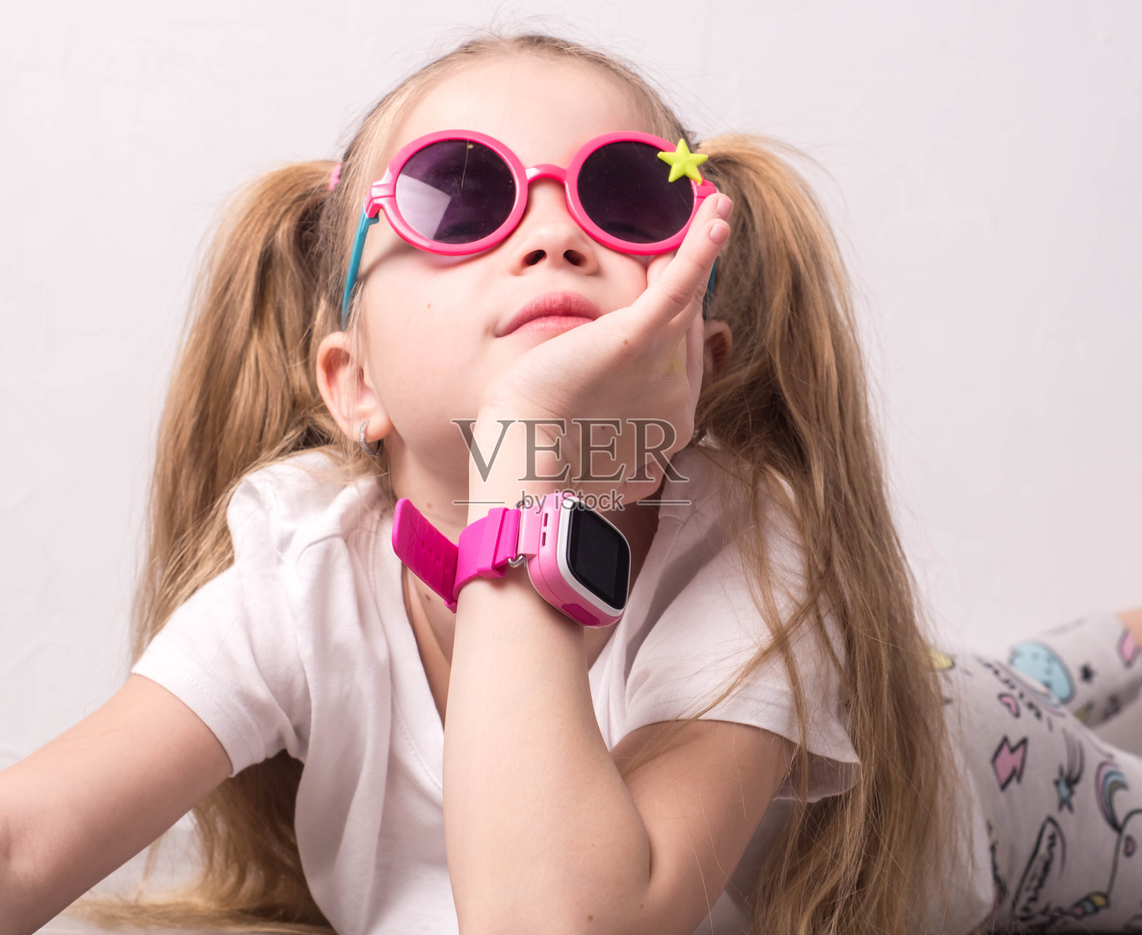 儿童科技:一个戴着粉色眼镜的女孩用着智能手表照片摄影图片
