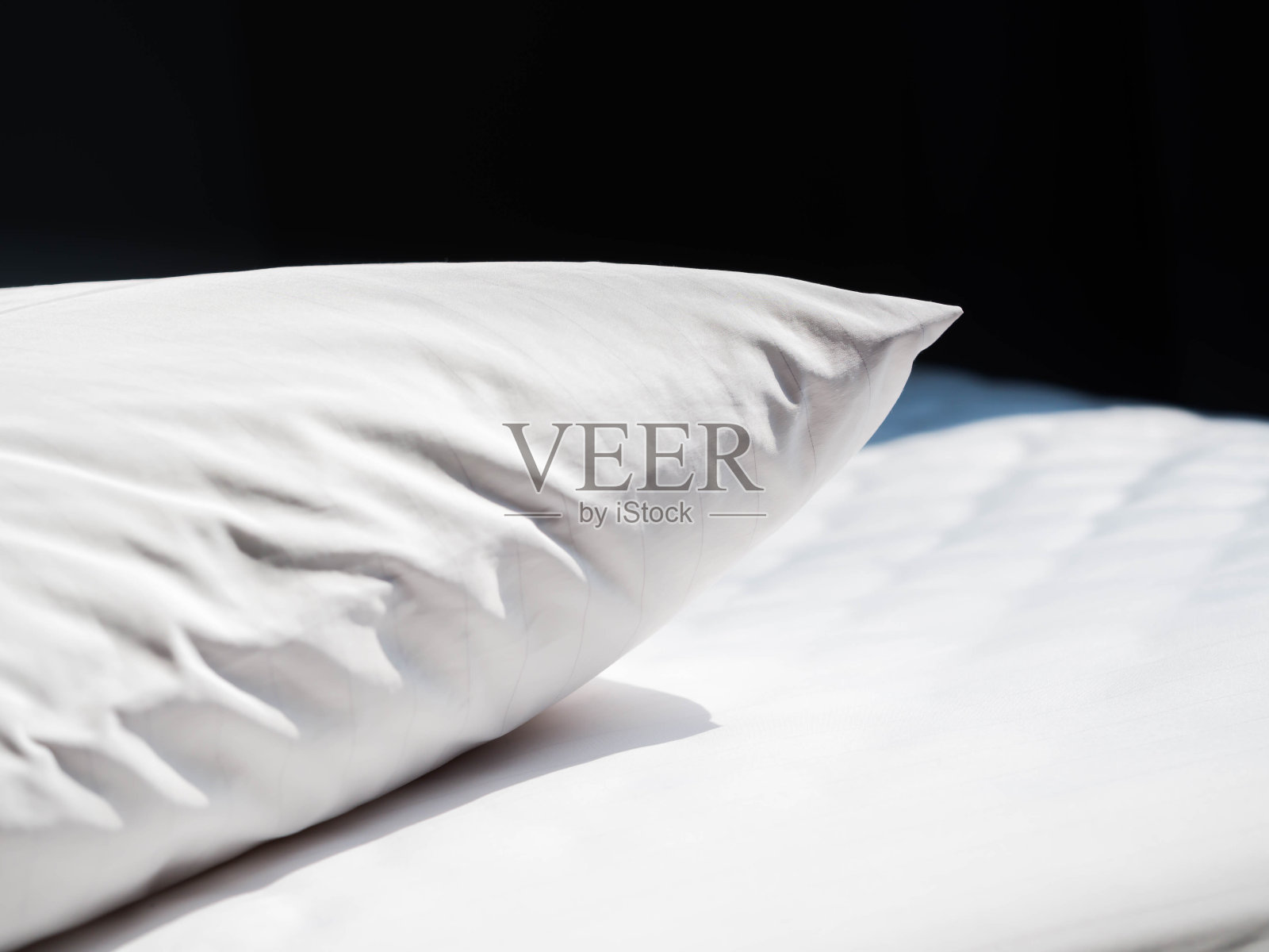 白色皱纹尘螨枕头和被套与黑色背景的卧室。照片摄影图片