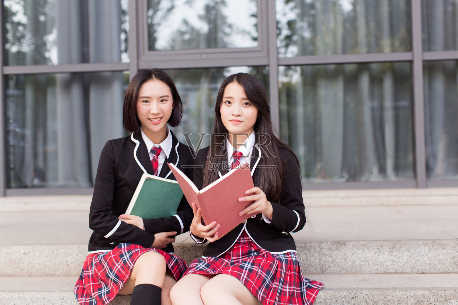 两个穿着校服的亚洲少女坐在台阶上照片摄影图片