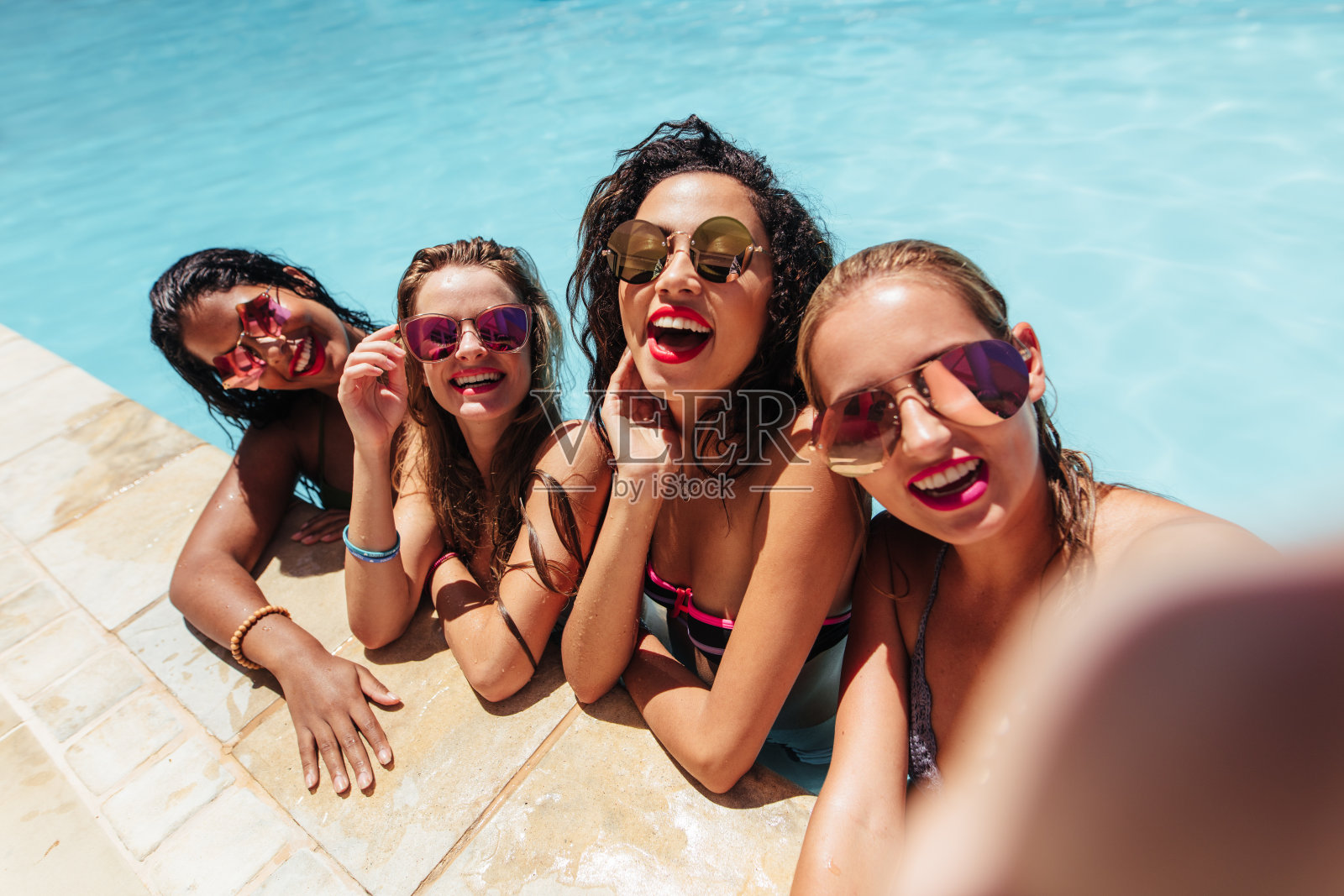 一群朋友在游泳池自拍。照片摄影图片