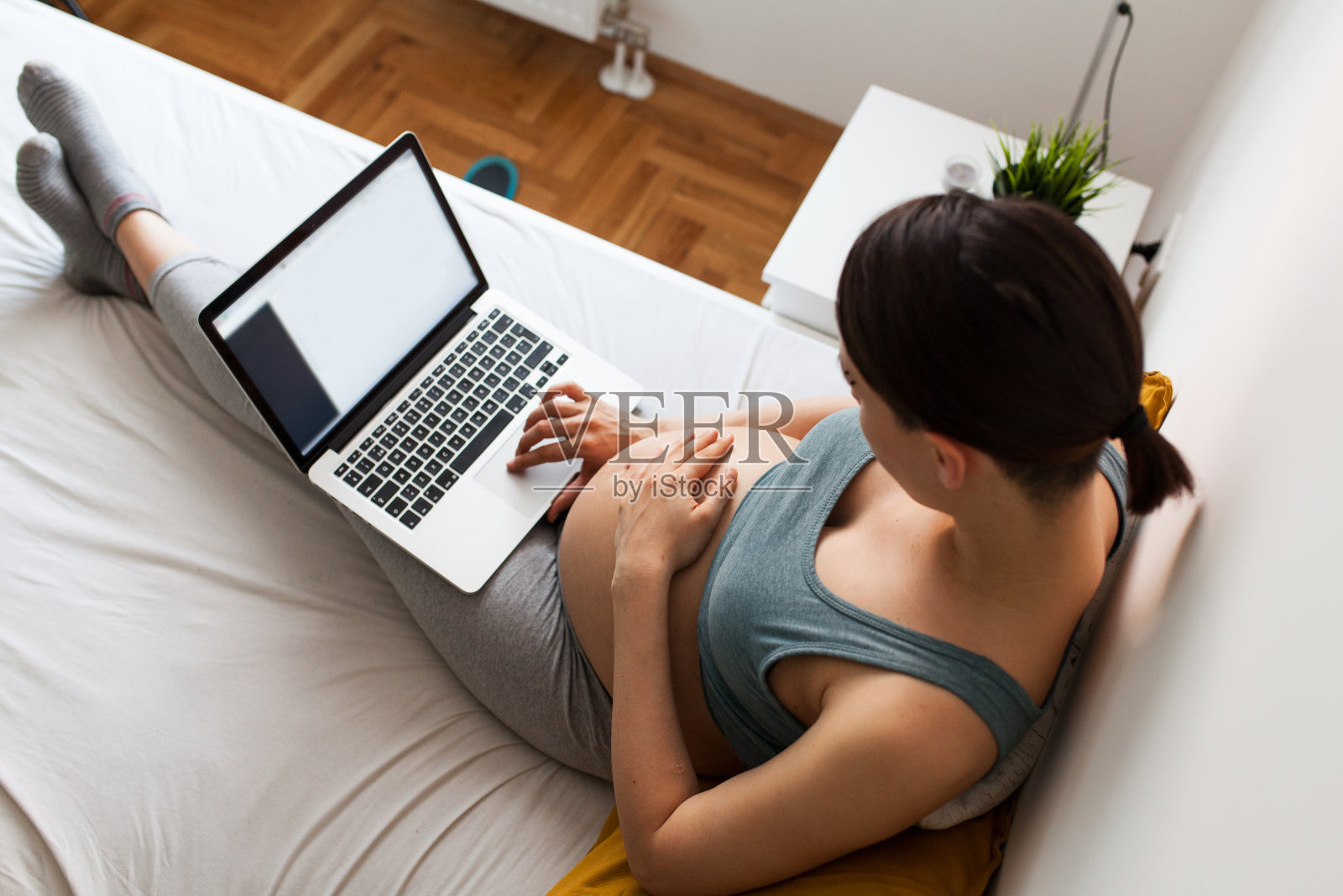 在床上用笔记本电脑看孕妇照片摄影图片