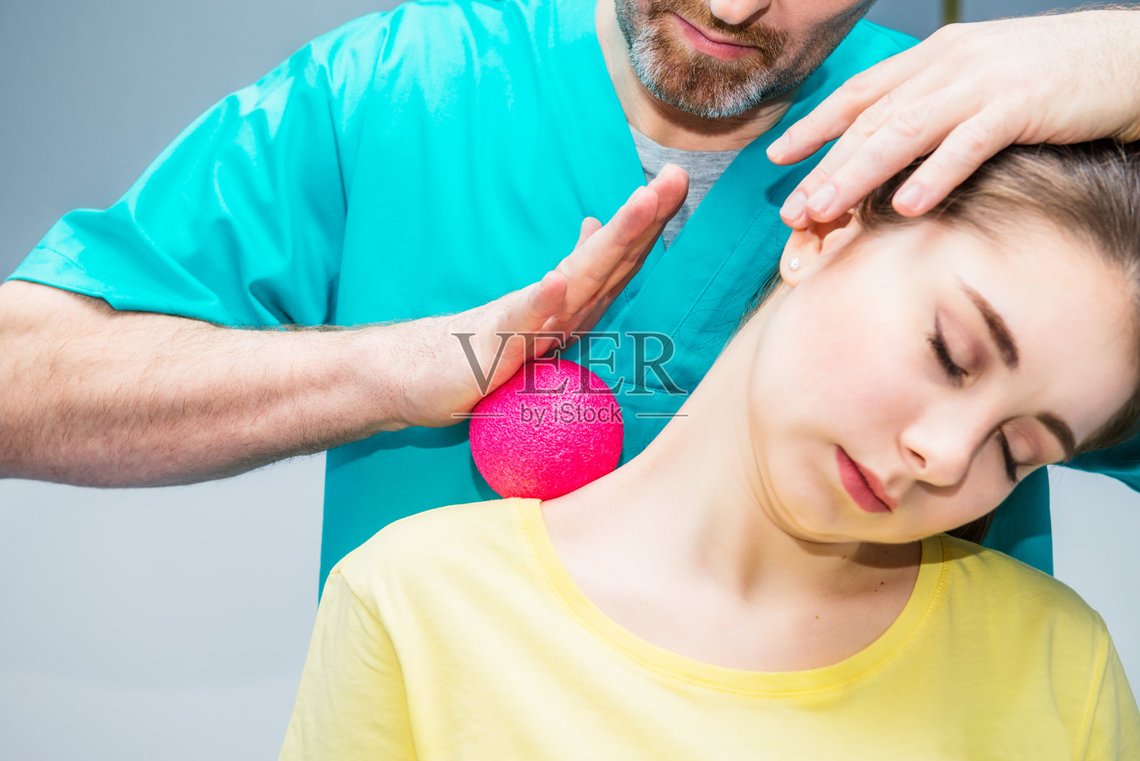 女子在理疗接受球按摩从治疗师。脊椎指压师在诊所治疗病人的肩、颈。神经学、整骨疗法,按摩。选择性聚焦，特写。照片摄影图片