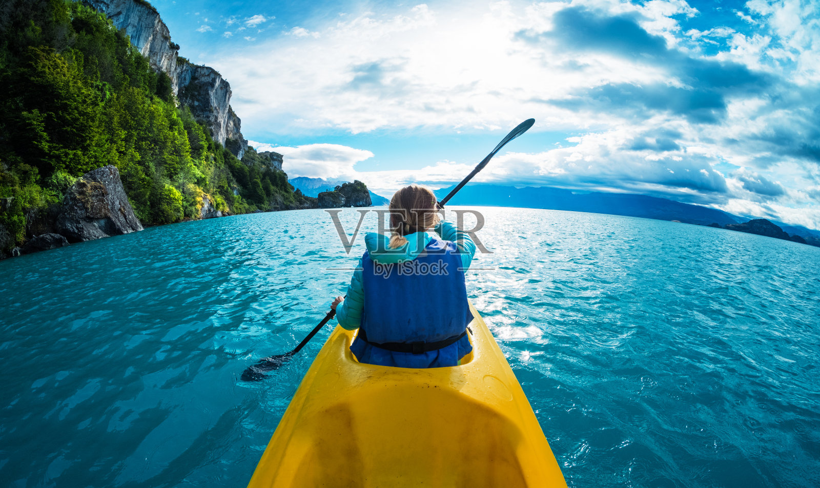 女子在碧绿的湖水中划着皮划艇照片摄影图片