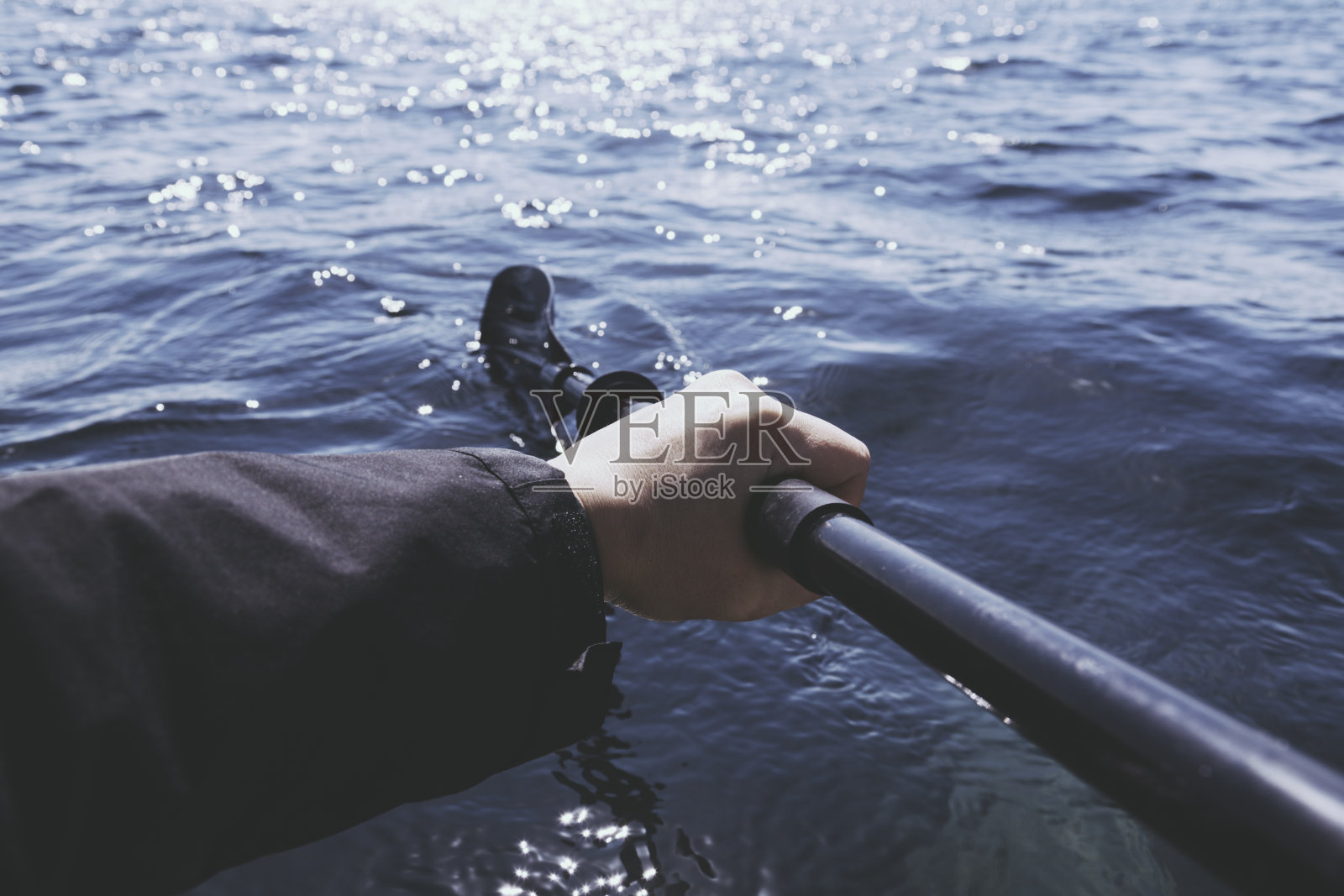 在海上划着皮划艇的人。照片摄影图片