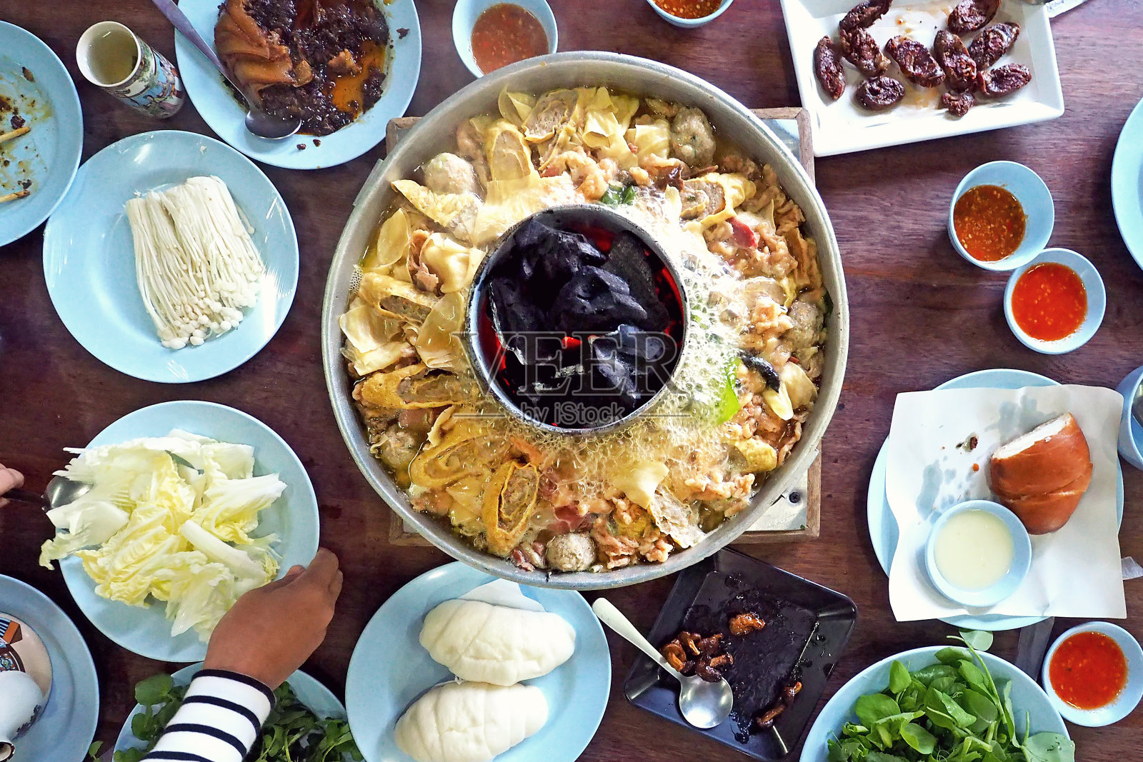 一家人在餐桌中央享用传统的亚洲中国云南式火锅——从上面拍摄的照片照片摄影图片