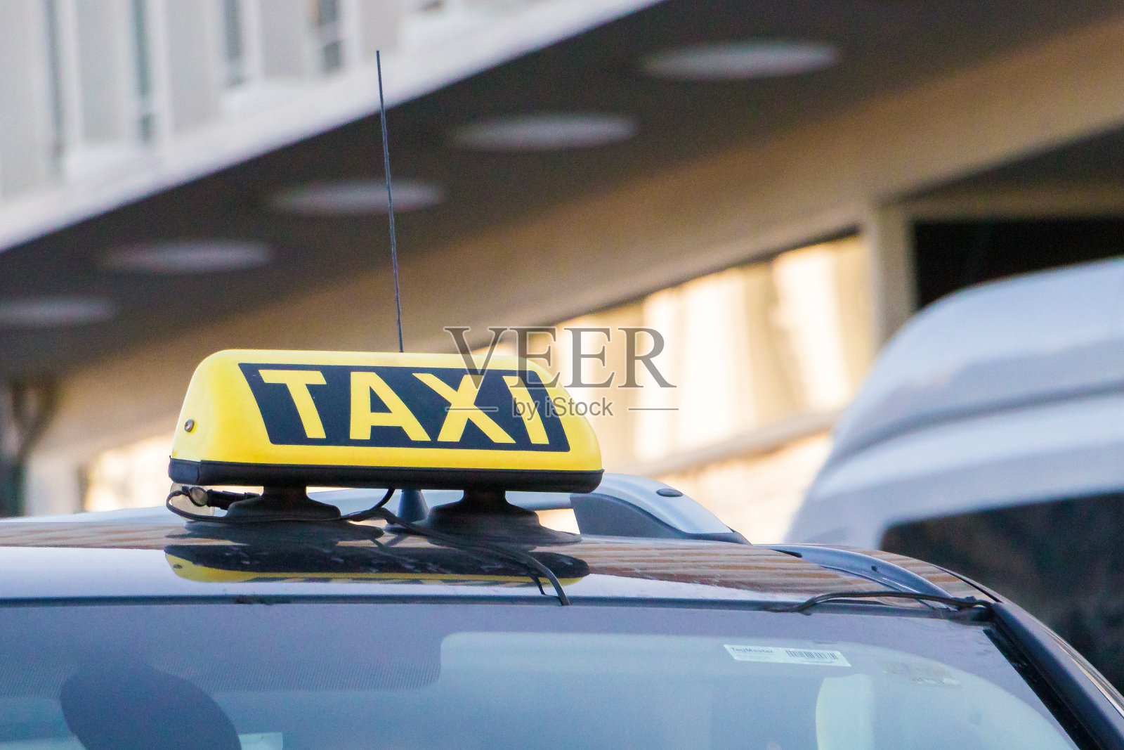 出租车在白天的街道上行驶，出租车的标志在出租车车顶上停车时，在马路上等待乘客的老式胶片拍摄效果照片摄影图片