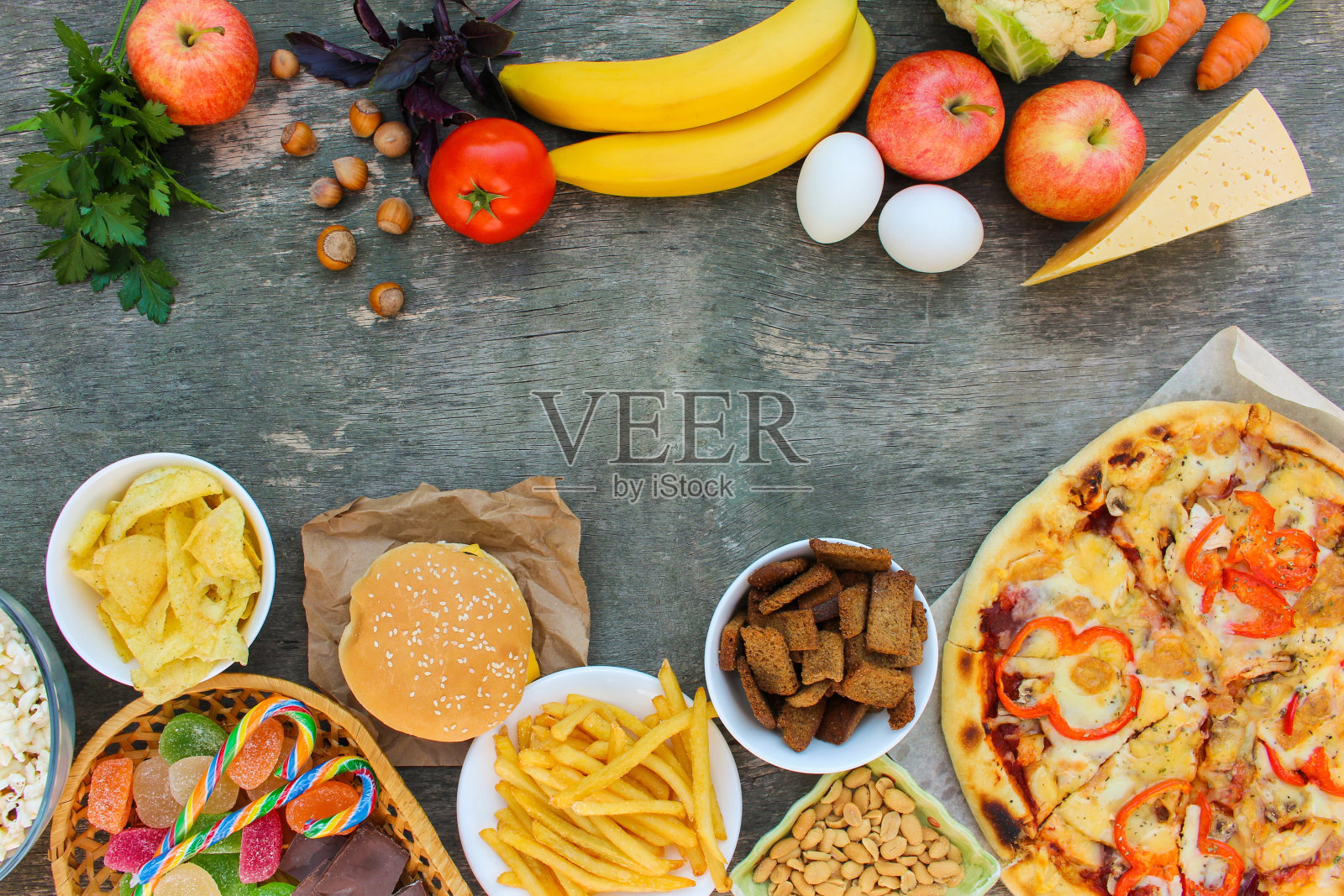 快餐和健康食品在旧的木制背景。概念选择正确的营养或垃圾食品。前视图。照片摄影图片