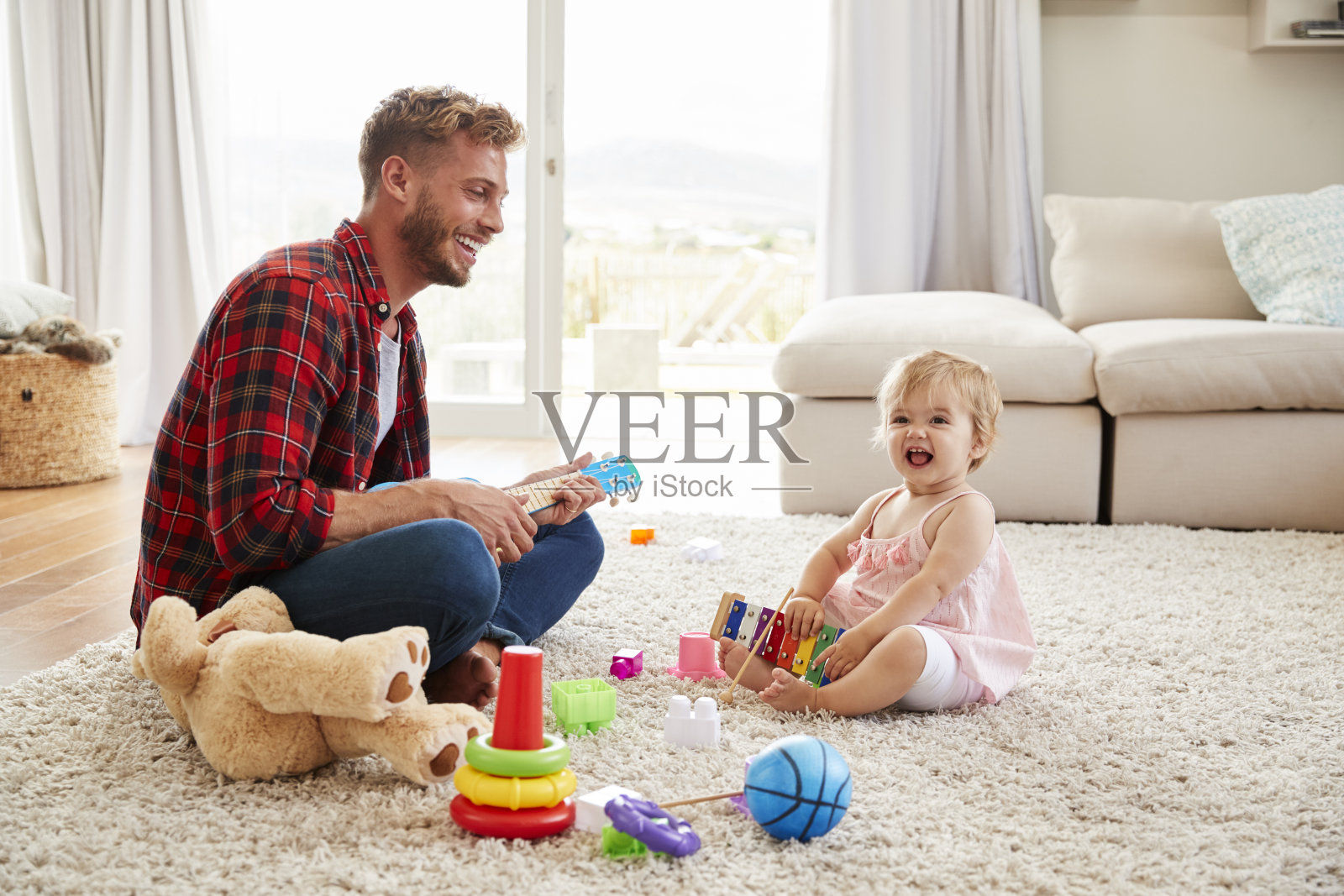 父亲和小女儿在家里玩玩具乐器照片摄影图片