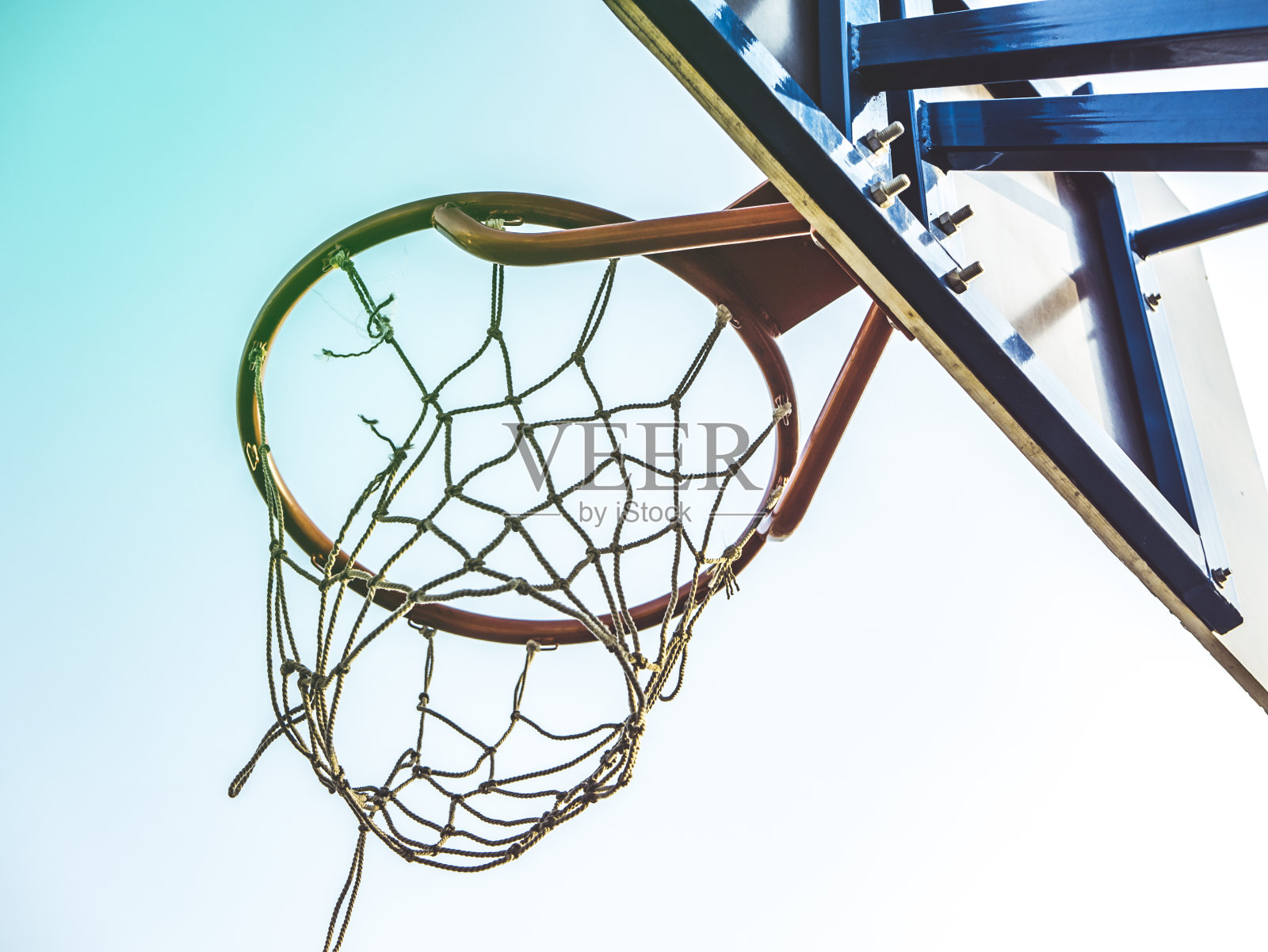 在一个晴朗的日子里，靠近篮球篮照片摄影图片