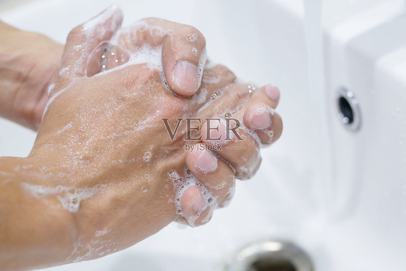 卫生。清洁双手。用水在水龙头下用肥皂洗手。照片摄影图片