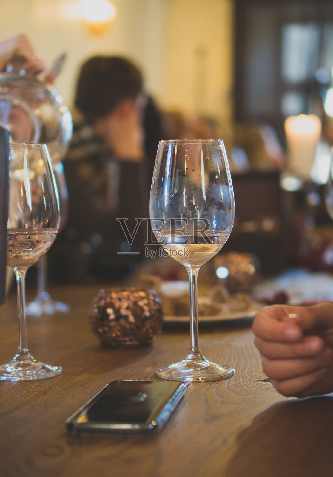 桌上放着一杯白葡萄酒。在酒吧聚会。照片摄影图片