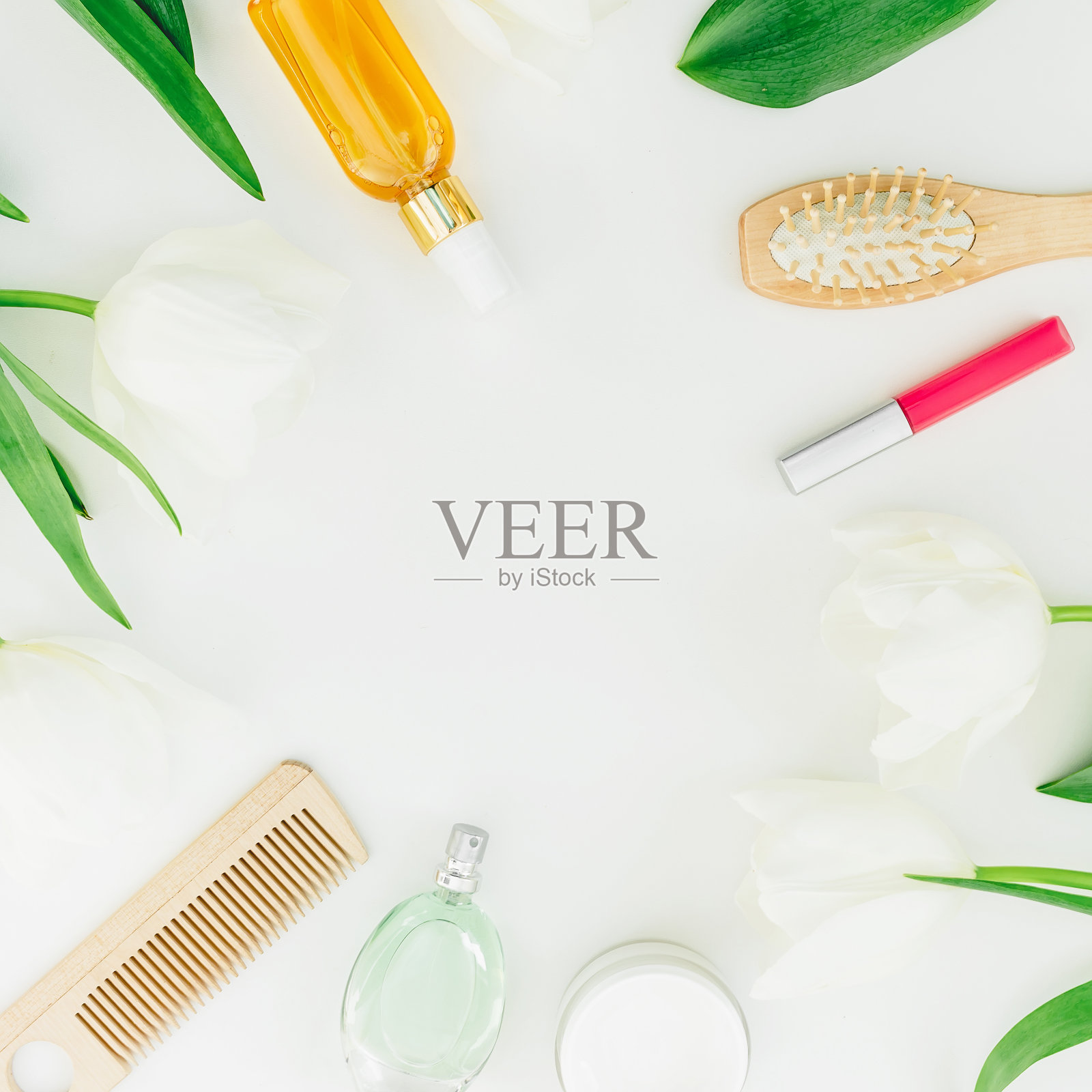 框架与化妆品，香水，梳子和郁金香花在白色的背景。美丽的博客组成。平躺，俯视图照片摄影图片