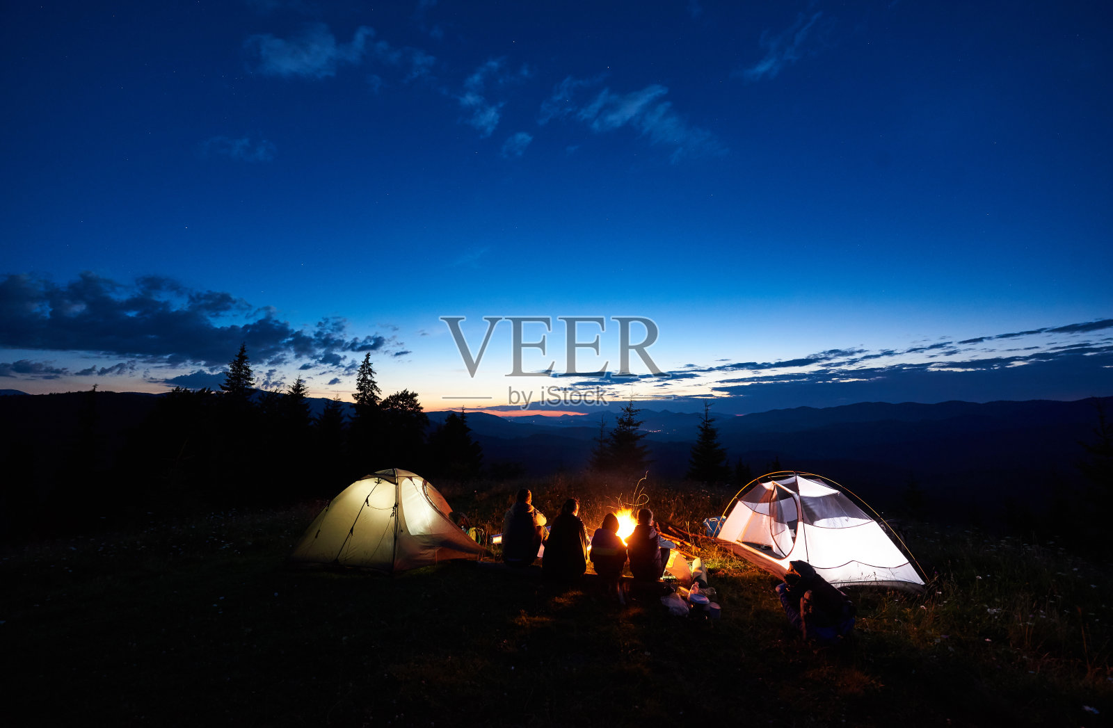 家庭远足者晚上在山上露营休息照片摄影图片