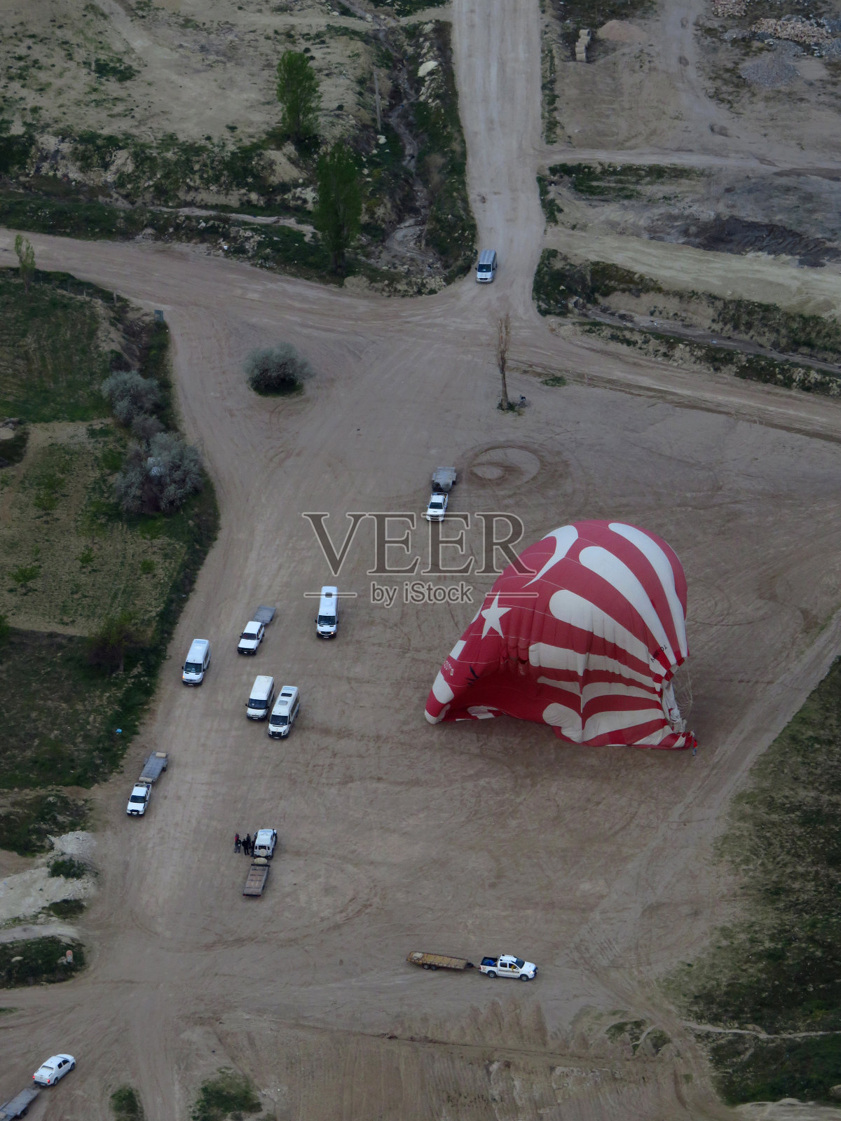 从上面看到的土耳其红色和白色热气球降落照片摄影图片