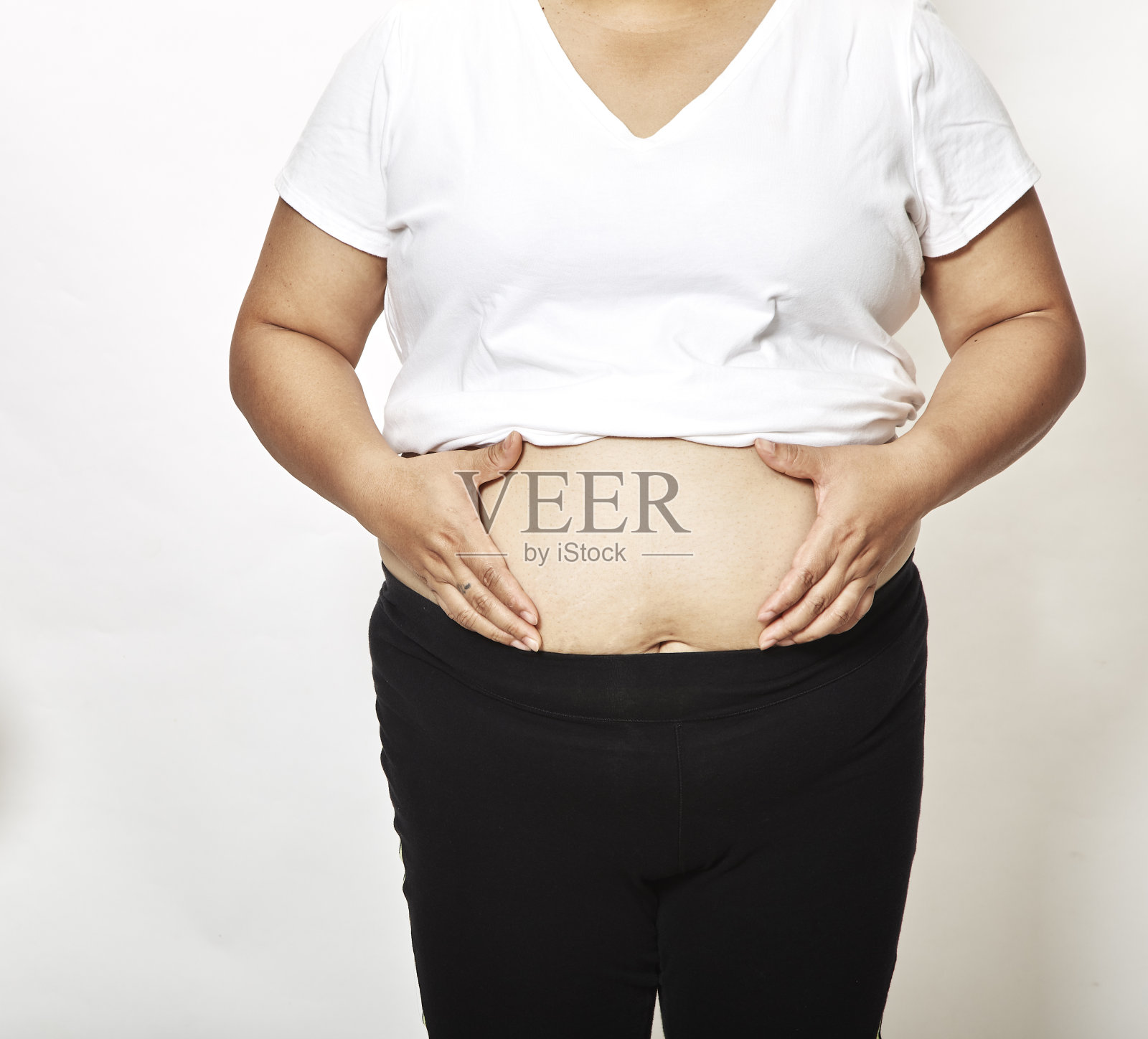 女人测量她的腰围，肥胖的肚子照片摄影图片