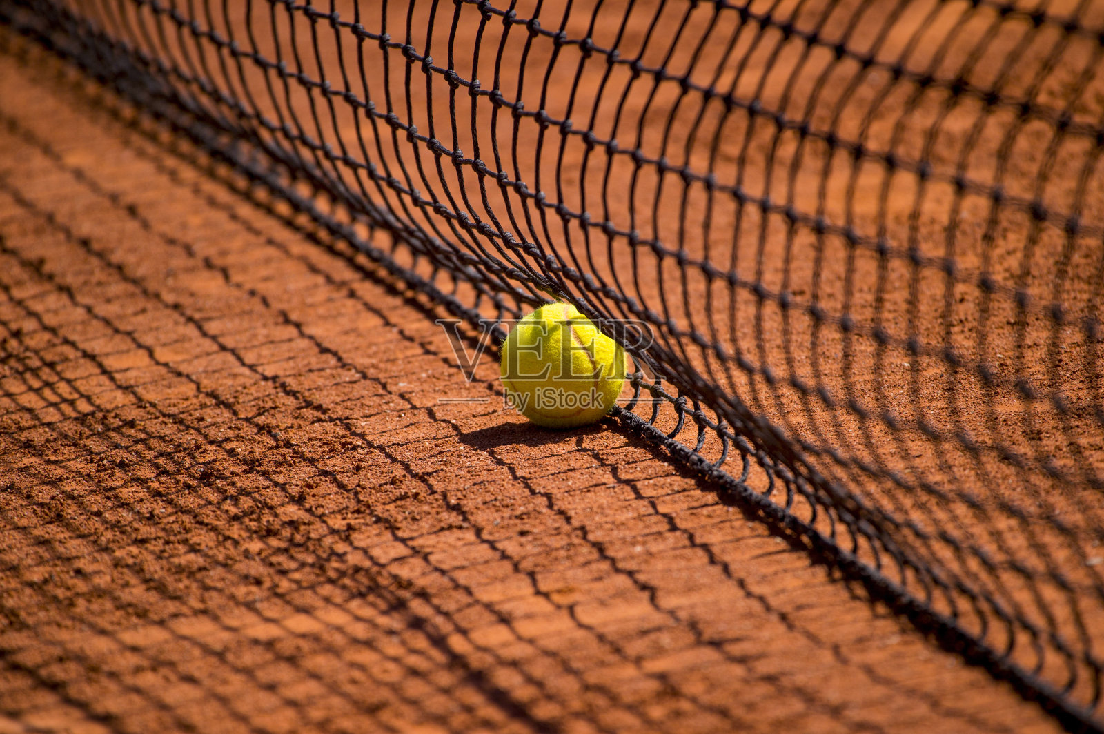 红土场地上的网球网，装有快速网球照片摄影图片