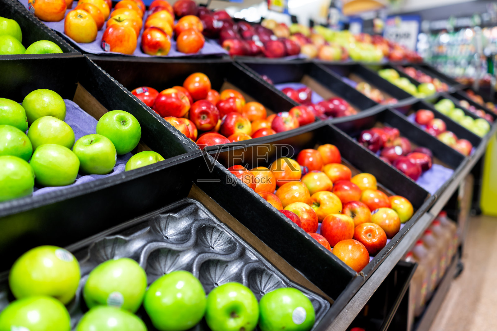 许多品种什锦红苹果陈列在食品店的货架上，在过道里，超市里面，没有人，包括绿青霉照片摄影图片