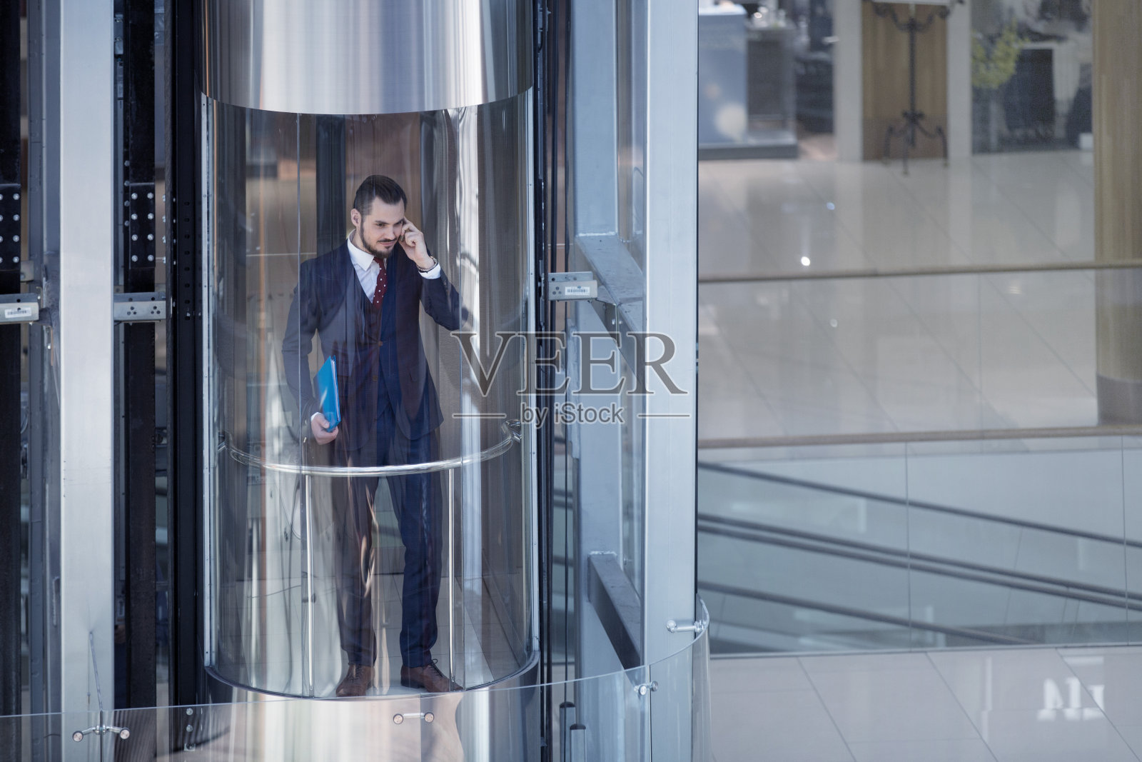 现代玻璃电梯里的商人照片摄影图片