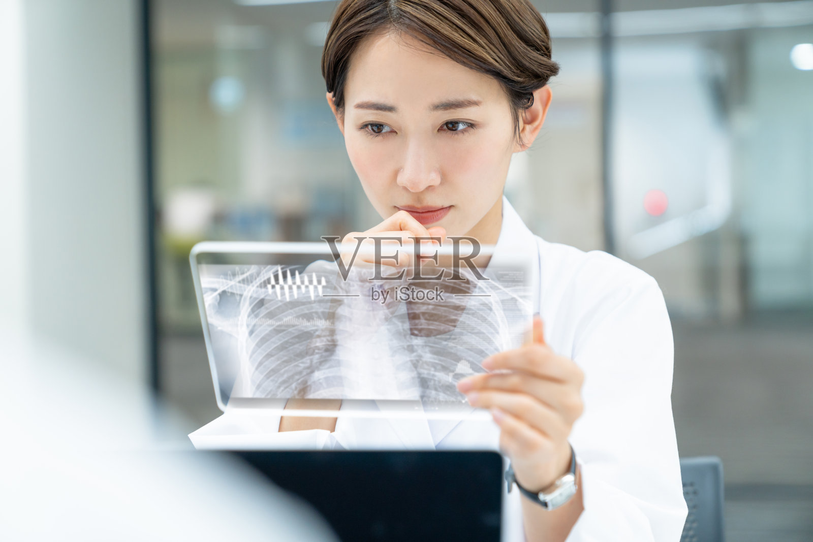 女医生看起来像一个未来的平板设备。电子医疗记录。照片摄影图片