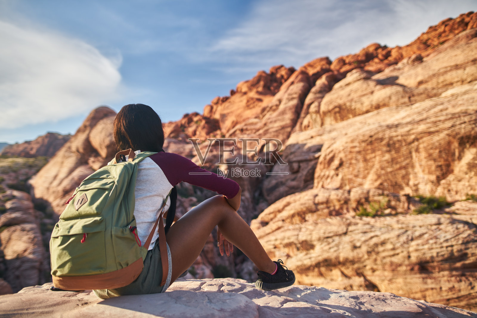 女徒步旅行者在红岩峡谷的岩架上看风景照片摄影图片